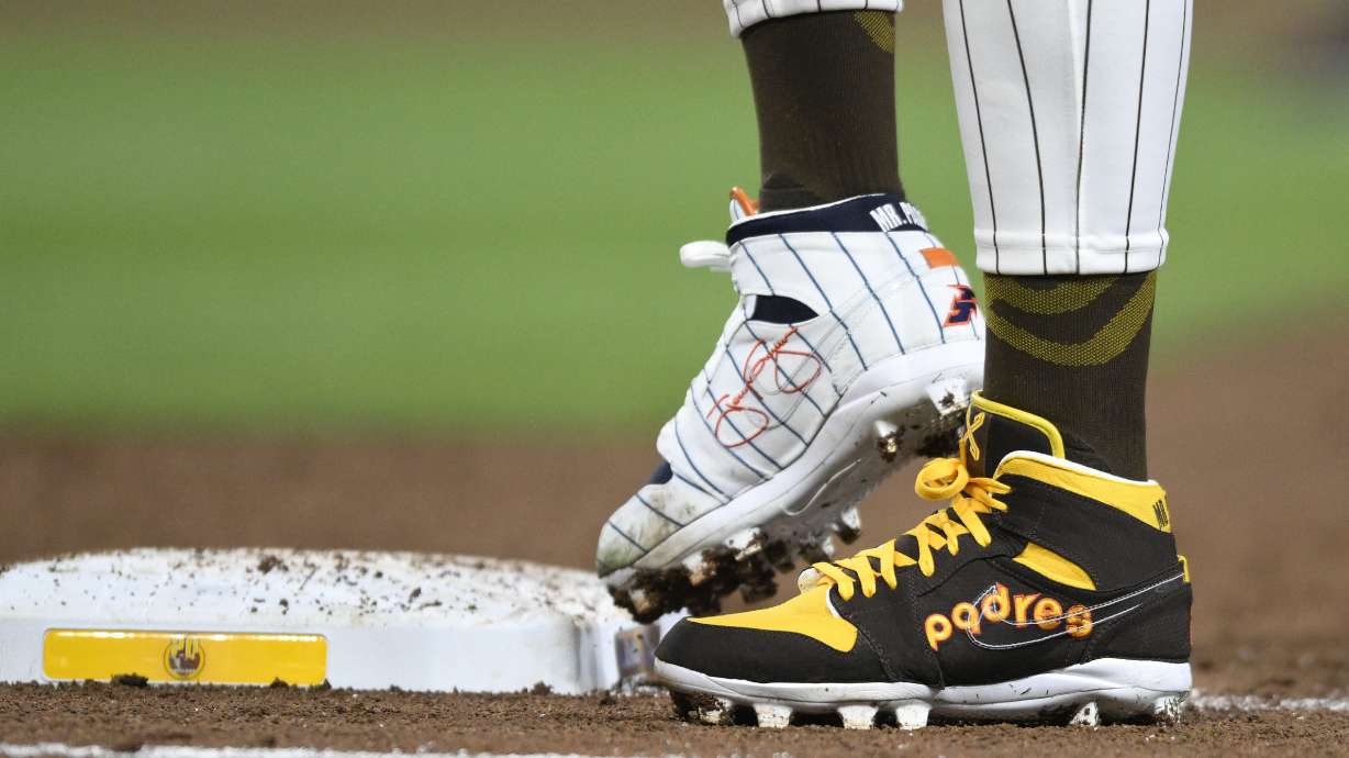 FILE - San Diego Padres' Fernando Tatis Jr. (23) wears cleats commemorating the Padres's 1980's and 1990's teams during a baseball game against the Chicago Cubs, Monday, April 8, 2024, in San Diego. Tatis plans to unveil 50 pairs of custom cleats this season in conjunction with his branding company, Xample, and Los Angeles-based Shoe Surgeon. The cleats will honor people, events and whatever strikes the 25-year-old Tatis' fancy.