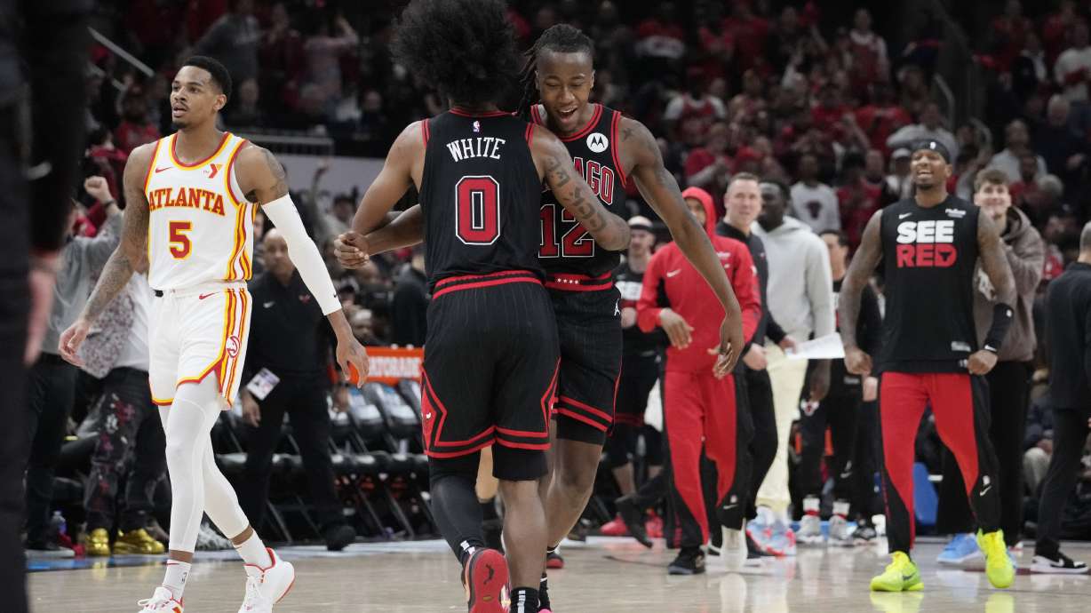 Chicago Bulls guard Coby White (0) celebrates with guard Ayo Dosunmu after a Bulls basket during the second half of the team's NBA basketball play-in tournament game against the Atlanta Hawks in Chicago, Wednesday, April 17, 2024. The Bulls won 131-116.