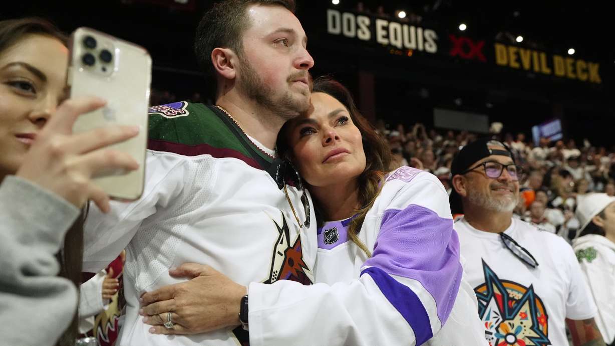 Arizona Coyotes season-ticket holders comfort one another as time expires in team's NHL hockey game against the Edmonton Oilers on Wednesday, April 17, 2024, in Tempe, Ariz. The Coyotes won 5-2. Coyotes owner Alex Meruelo agreed to sell the franchise's hockey operations to Utah Jazz owner Ryan Smith, who intends to move the team to Salt Lake City.