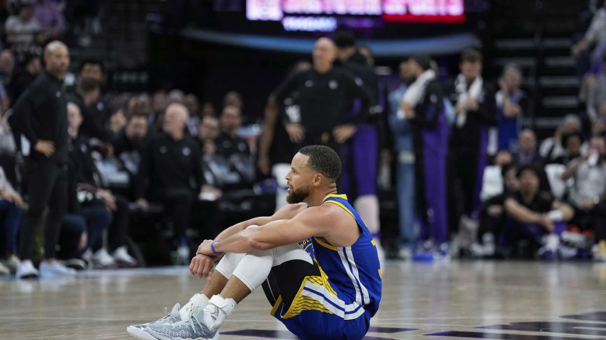 Golden State Warriors guard Stephen Curry sits on the court during the second half of the team's NBA basketball play-in tournament game against the Sacramento Kings, Tuesday, April 16, 2024, in Sacramento, Calif.