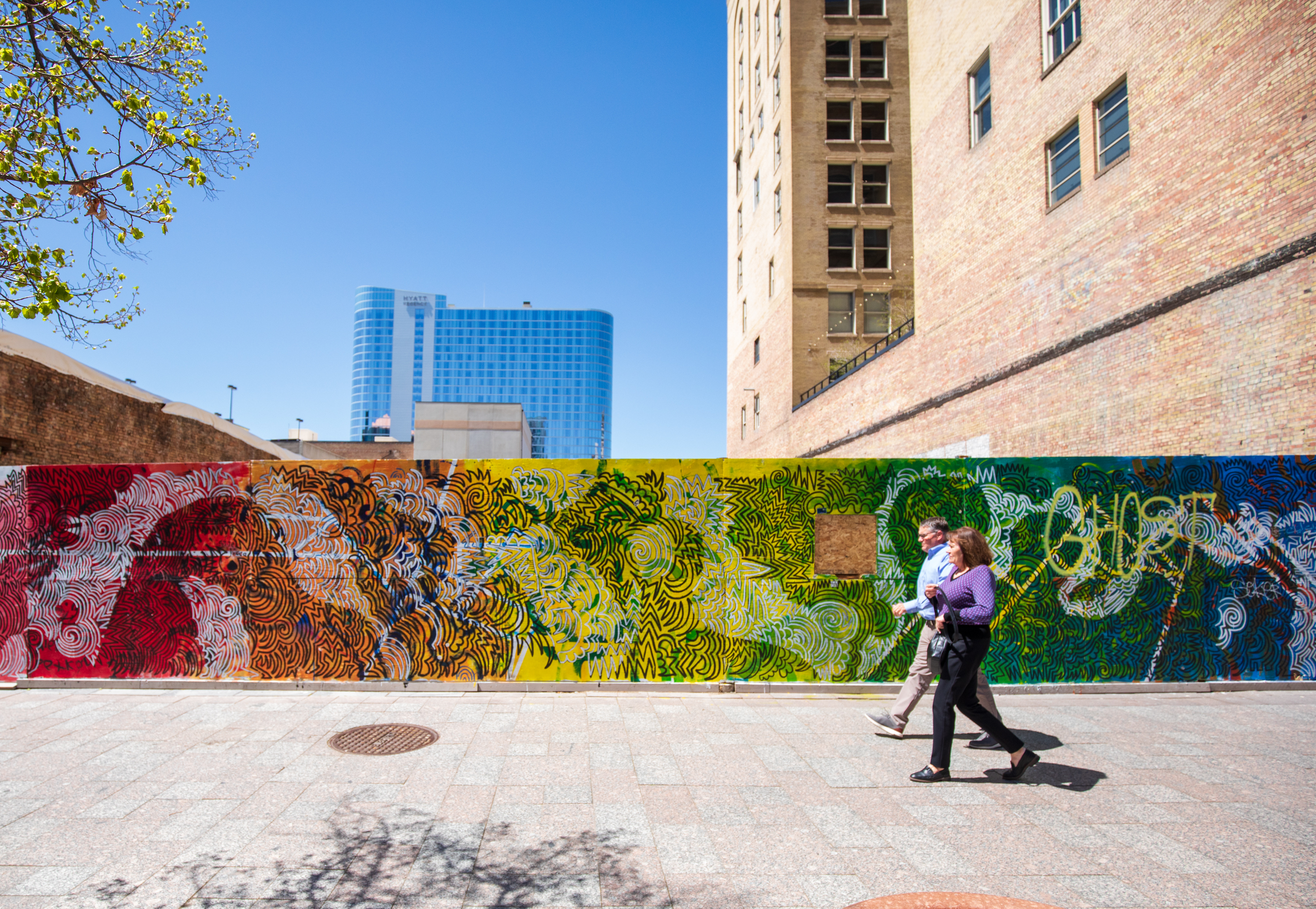 People walk past a mural on Main Street at the site where the Utah Pantages Theater once stood on Thursday.