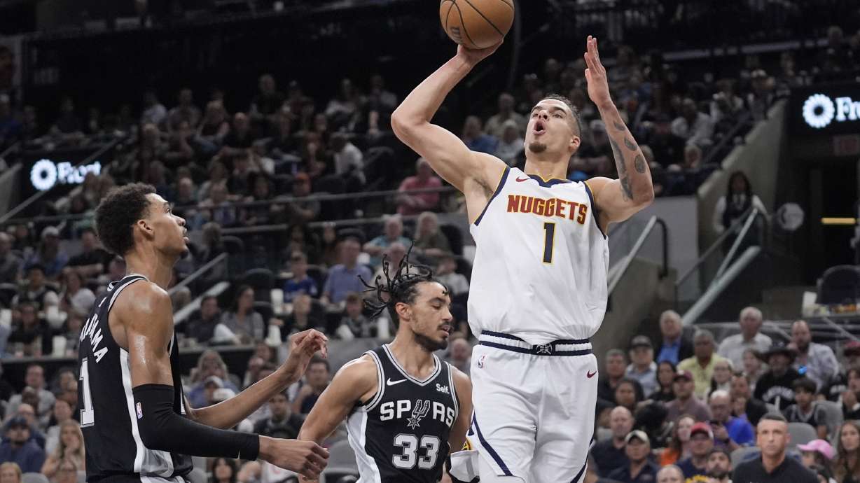 Denver Nuggets forward Michael Porter Jr., front right, shoots over San Antonio Spurs center Victor Wembanyama, left, and guard Tre Jones (33) during the first half of an NBA basketball game in San Antonio, Friday, April 12, 2024.