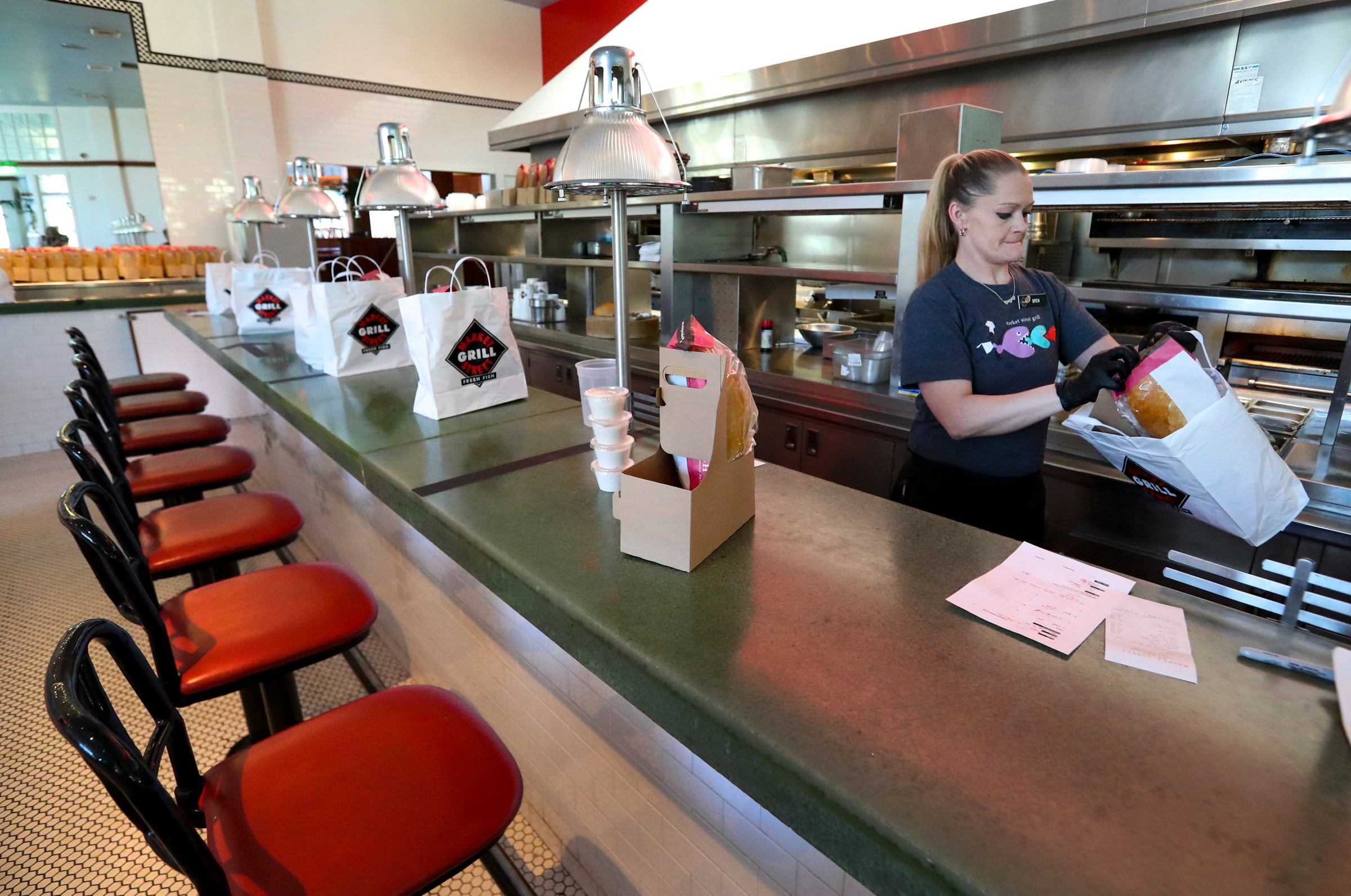 Server Brennan Feller prepares curbside pickup orders at Market Street Grill in Cottonwood Heights on April 28, 2020.