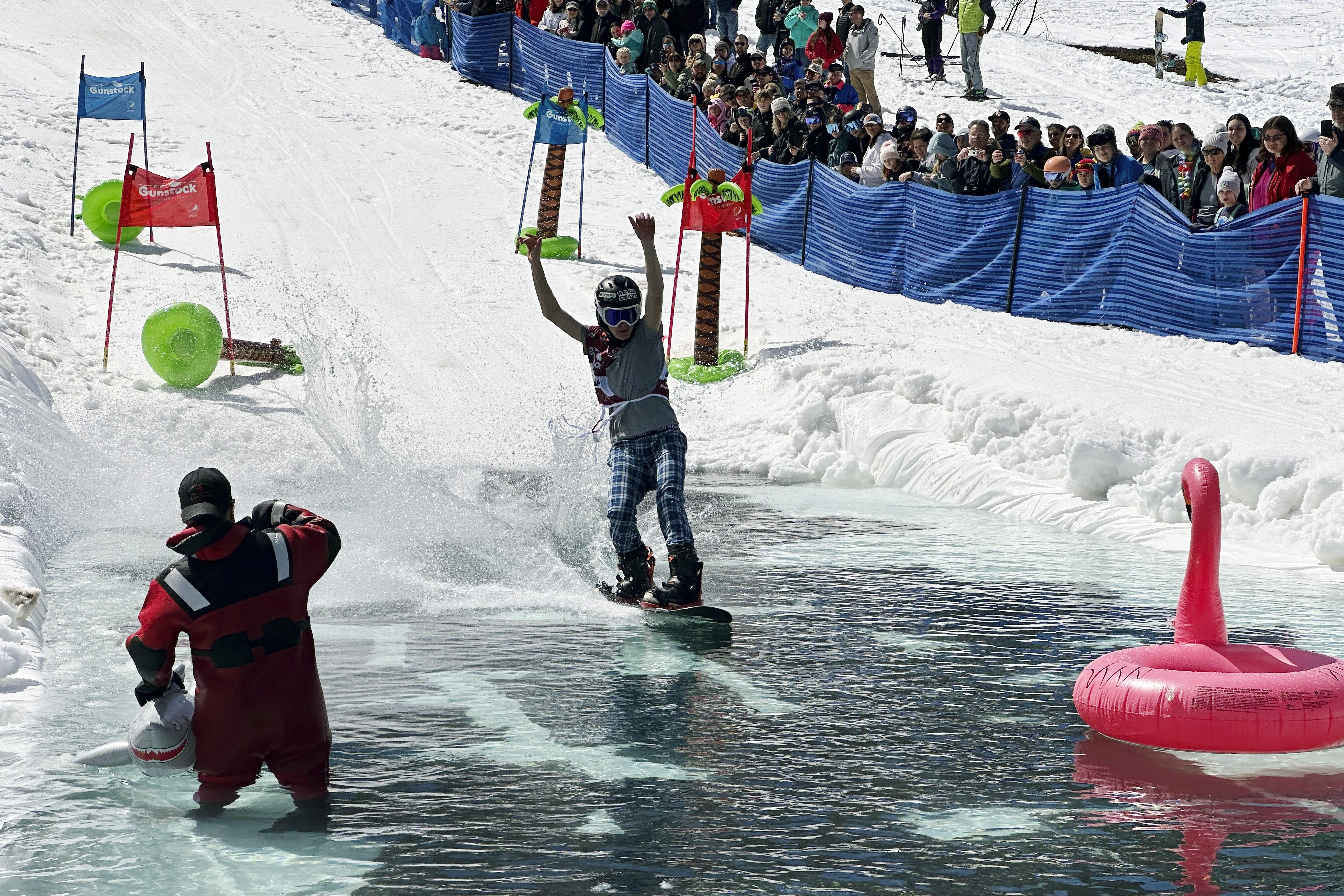 A snowboarder participates in a pond skimming event at Gunstock Mountain Resort, Sunday, April 7, 2024, in Gilford, N.H. The wacky spring tradition is happening this month at ski resorts across the country and is often held to celebrate the last day of the skiing season.