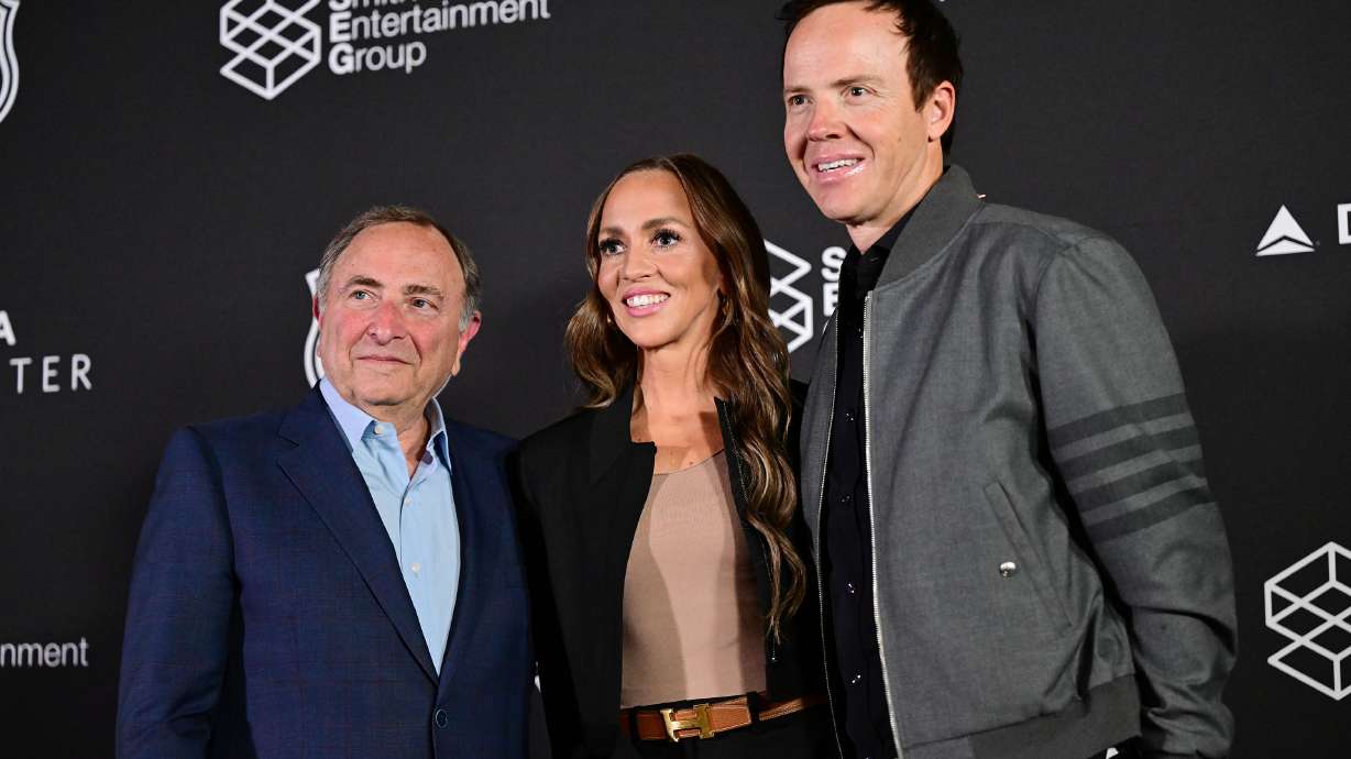 Ryan Smith and Ashley Smith pose with NHL Commissioner Gary Bettman after their press conference at the Delta Center in Salt Lake City on April 18 after announcing the NHL is coming to Utah.