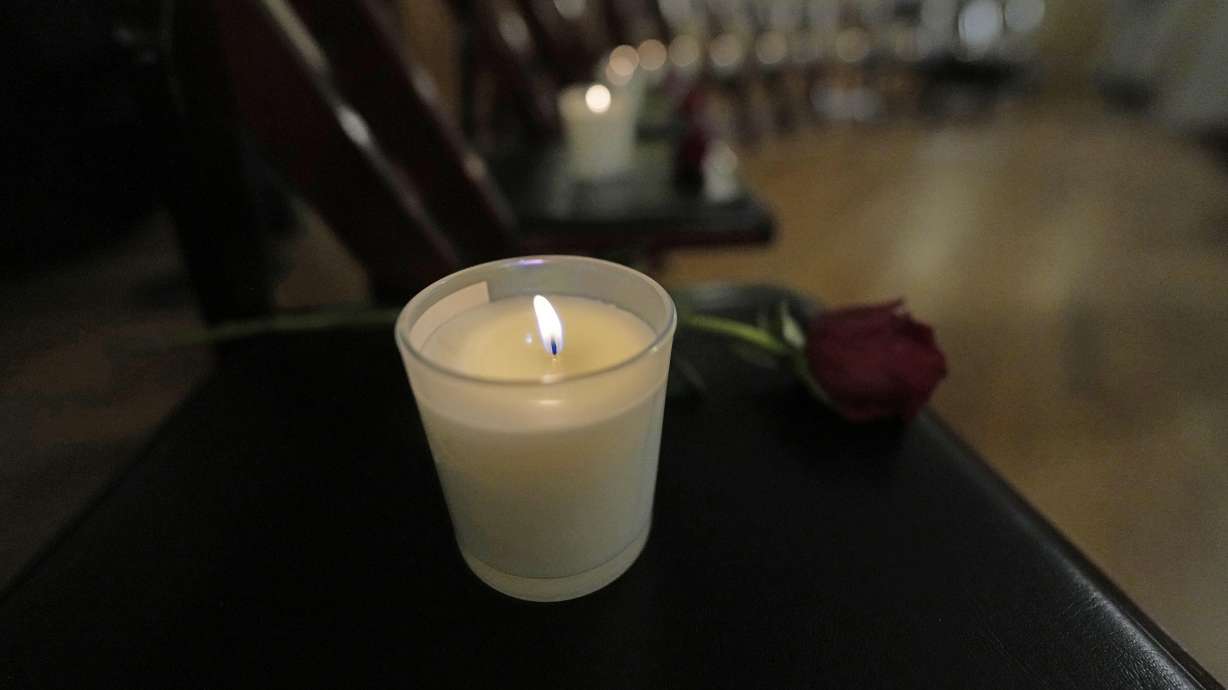Thirteen chairs are empty with candles and roses to remember 25th anniversary of the Columbine High School mass shooting on Friday in Denver.
