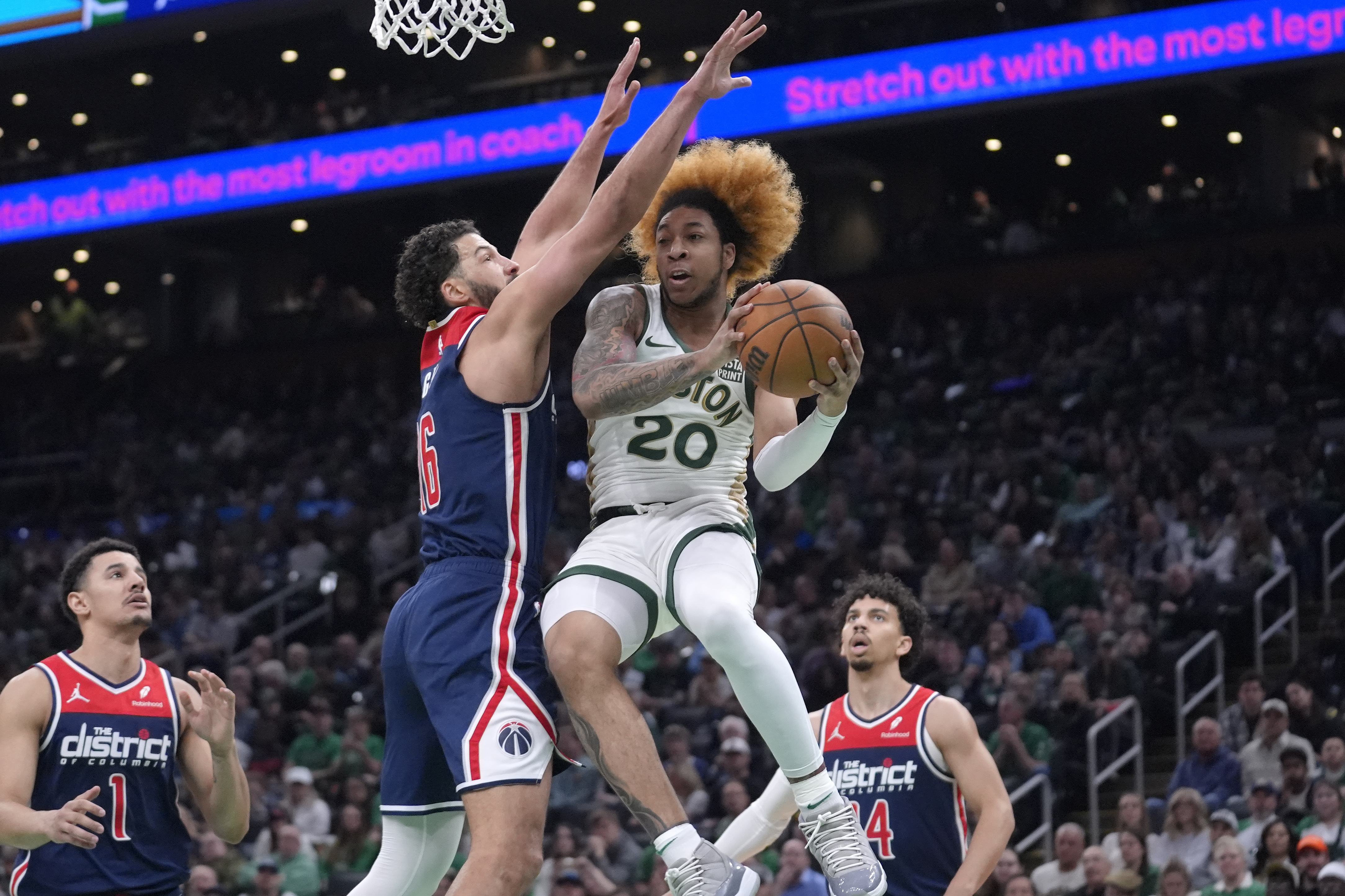 Boston Celtics guard JD Davison (20) drives toward the basket as Washington Wizards forward Anthony Gill, center left, defends in the first half of an NBA basketball game, Sunday, April 14, 2024, in Boston.