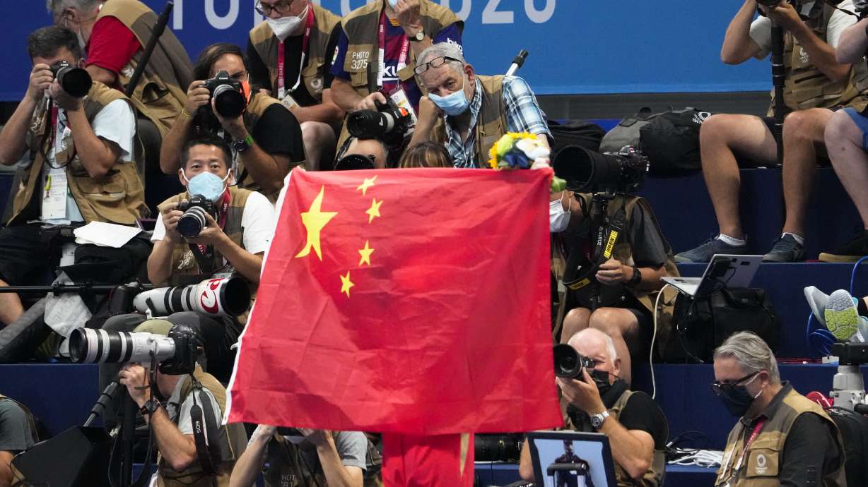 FILE - A Chinese flag is unfurled on the podium of a swimming event final at the 2020 Summer Olympics, on July 29, 2021, in Tokyo, Japan. An Australian newspaper said Saturday, April 20, 2024, 23 Chinese swimmers were cleared to compete at the Tokyo Olympics despite testing positive to doping because world governing bodies agreed with Chinese authorities and ruled that the tests had been contaminated.