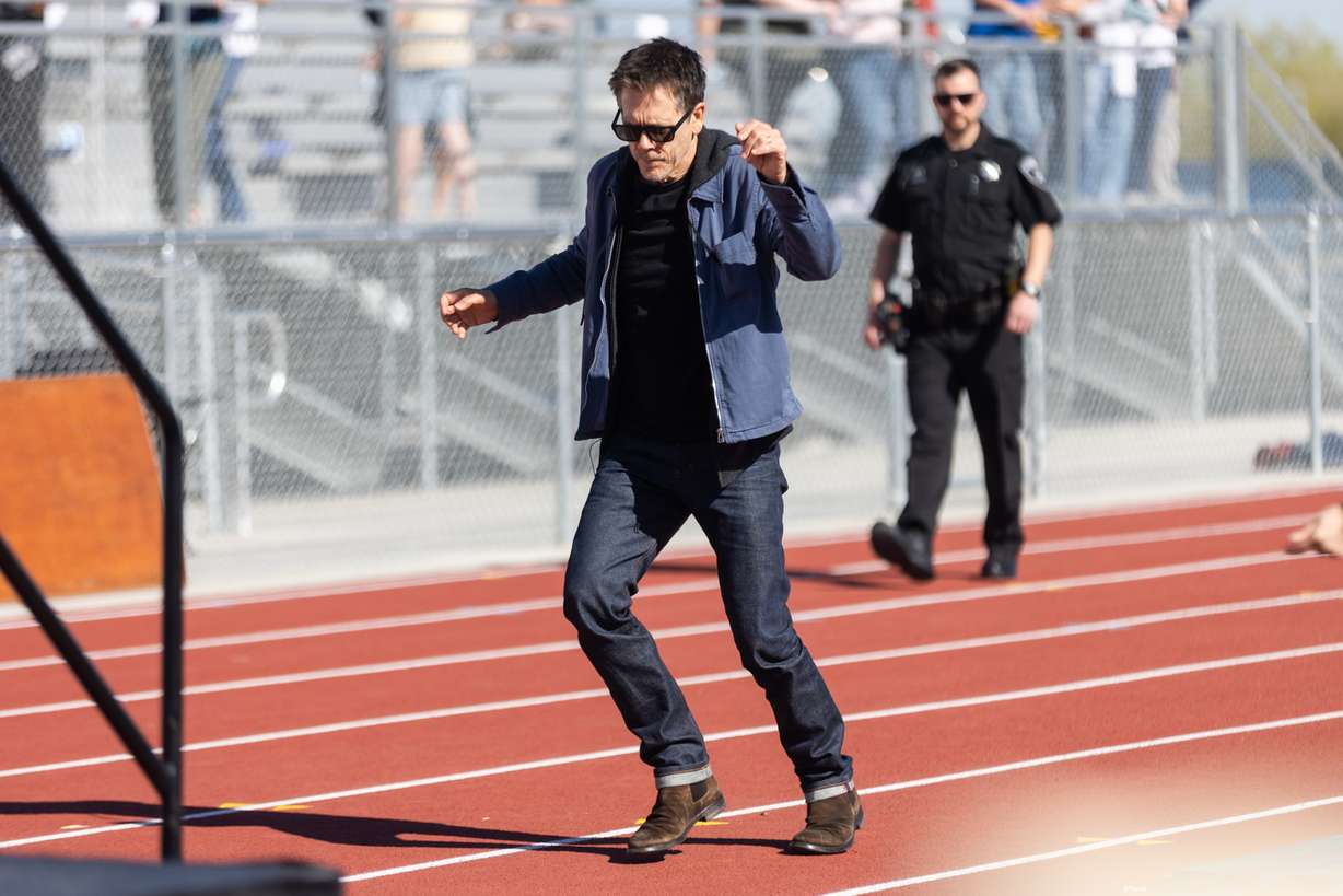 Kevin Bacon dances his way to the stage at Payson High School before partaking in a community kit-building program with Bacon’s charity Six Degrees in Payson on Saturday.