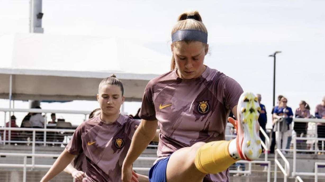 Ally Sentnor, left, and Mikayla Cluff, right, warm up in Louisville.