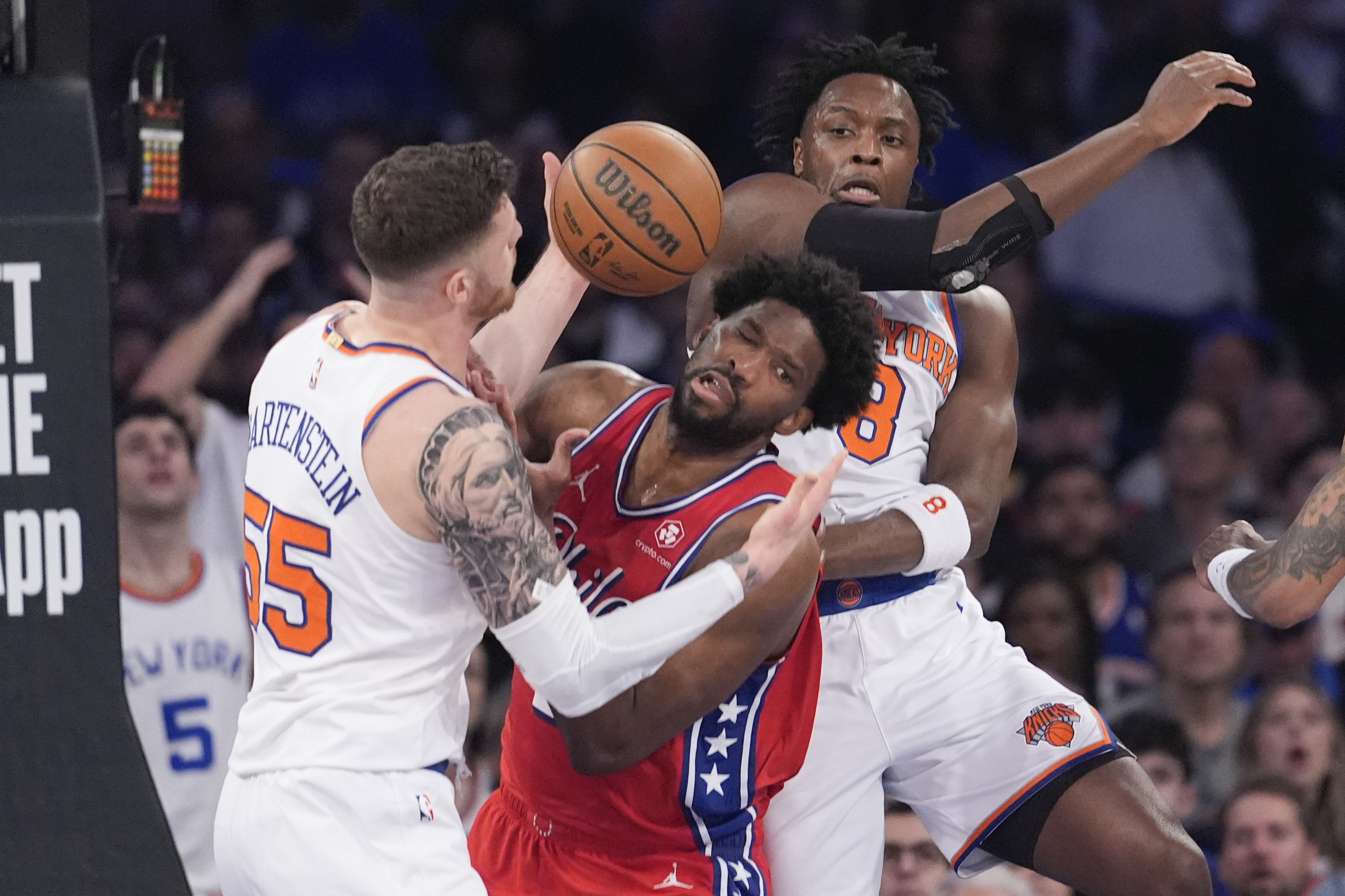 Philadelphia 76ers center Joel Embiid, center, fights for a rebound against New York Knicks center Isaiah Hartenstein (55) and forward OG Anunoby (8) during the first half in Game 1 of an NBA basketball first-round playoff series, Saturday, April 20, 2024, at Madison Square Garden in New York.