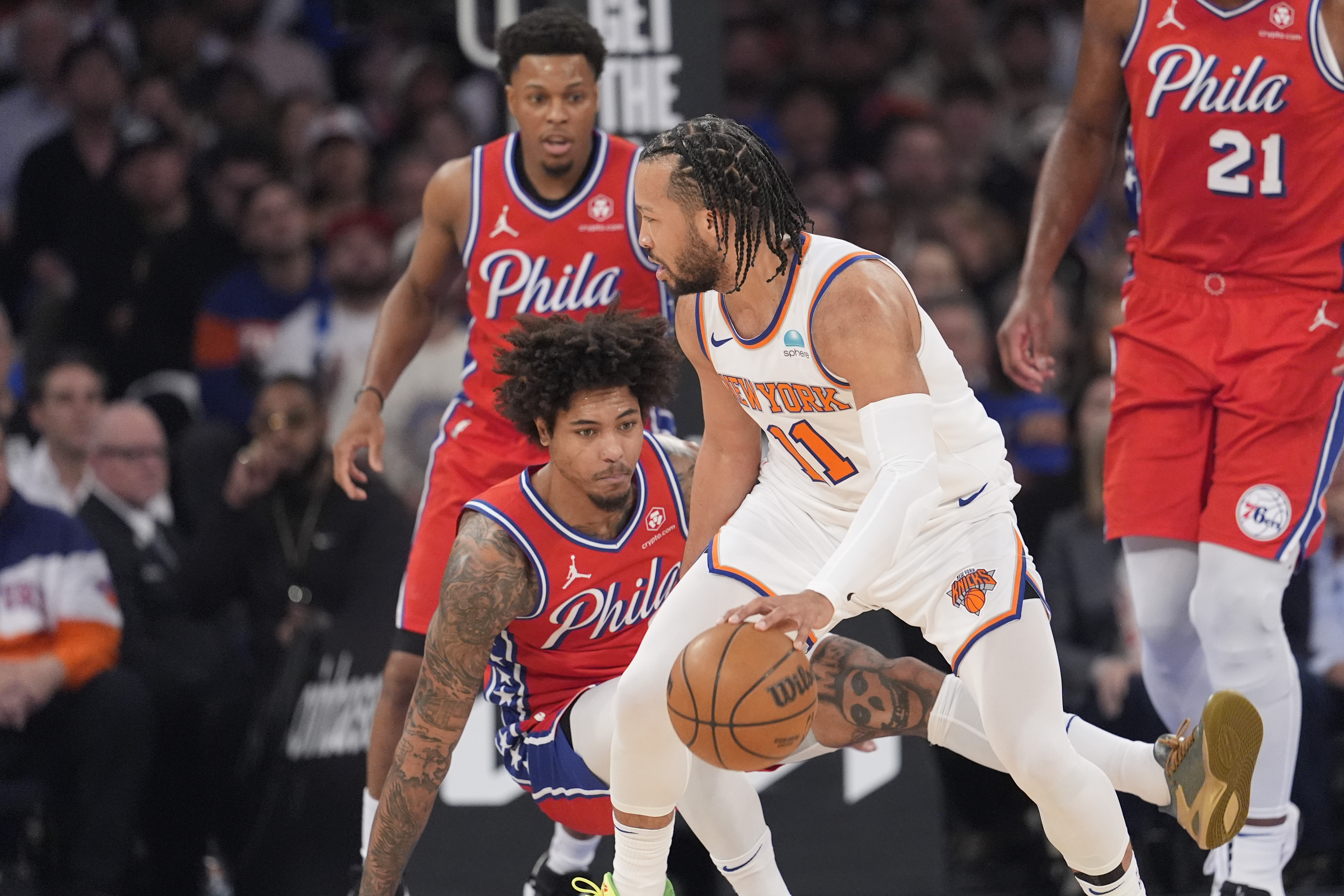 New York Knicks guard Jalen Brunson (11) drives against Philadelphia 76ers guard Kelly Oubre Jr., bottom center, and guard Kyle Lowry, back left, during the first half in Game 1 of an NBA basketball first-round playoff series, Saturday, April 20, 2024, at Madison Square Garden in New York. 