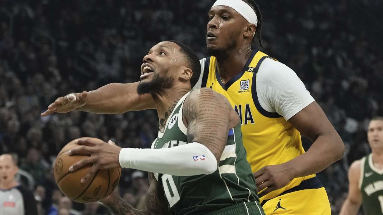 Milwaukee Bucks' Damian Lillard gets past Indiana Pacers' Myles Turner during the first half of Game 1 of the NBA playoff basketball game Sunday, April 21, 2024, in Milwaukee.