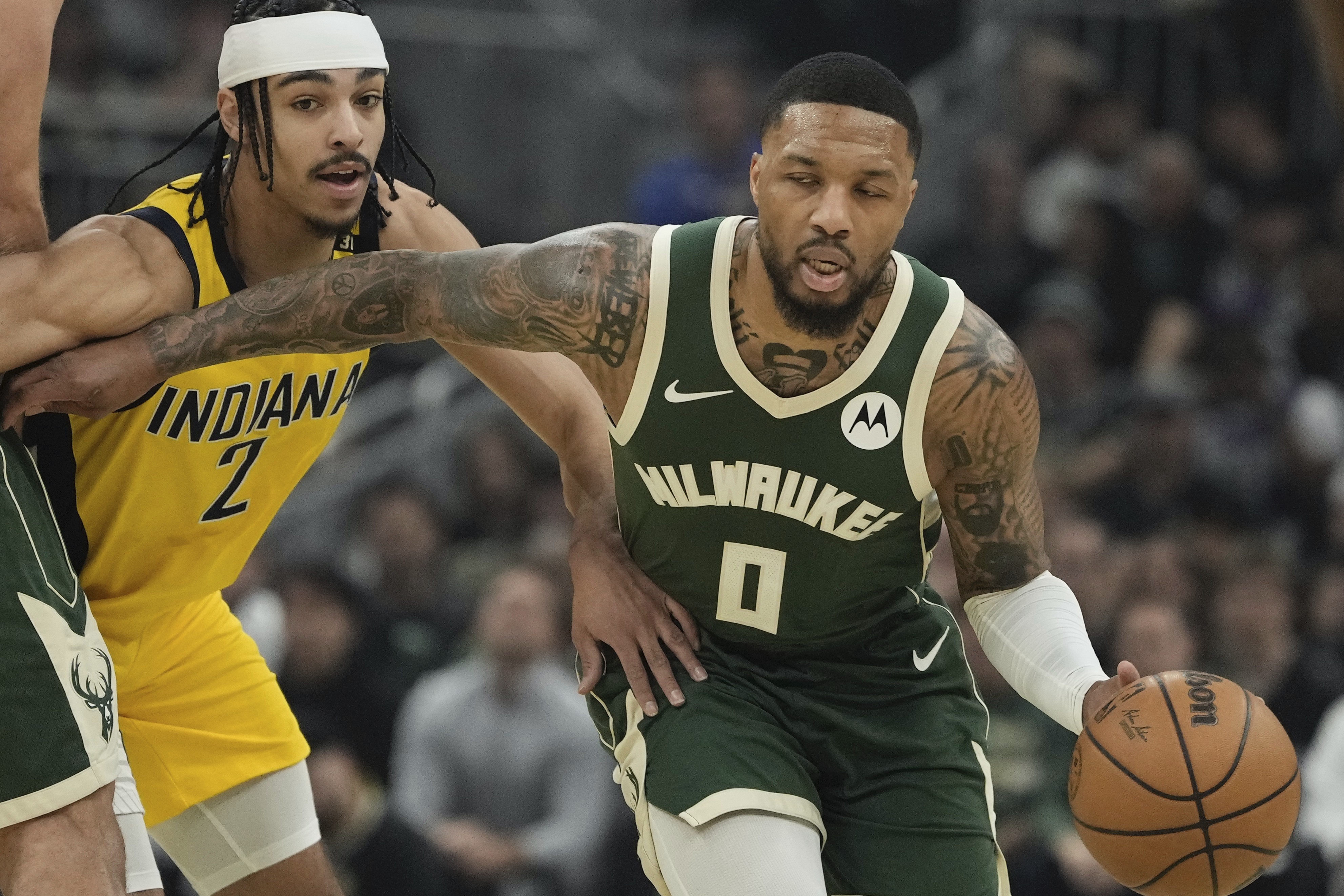Milwaukee Bucks' Damian Lillard gets past Indiana Pacers' Andrew Nembhard during the first half of Game 1 of the NBA playoff basketball game Sunday, April 21, 2024, in Milwaukee.