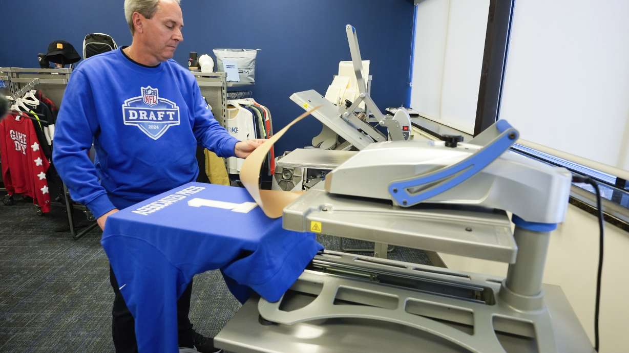 Brent Kisha, STAHLS' vice president of strategic sales, demonstrates using a Hotronix Fusion IQ heat press to put a name on shirt in St. Clair Shores, Mich., Monday, April 22, 2024. STAHLS' rapidly personalizes jerseys for each first-round pick as they are announced at the NFL draft.