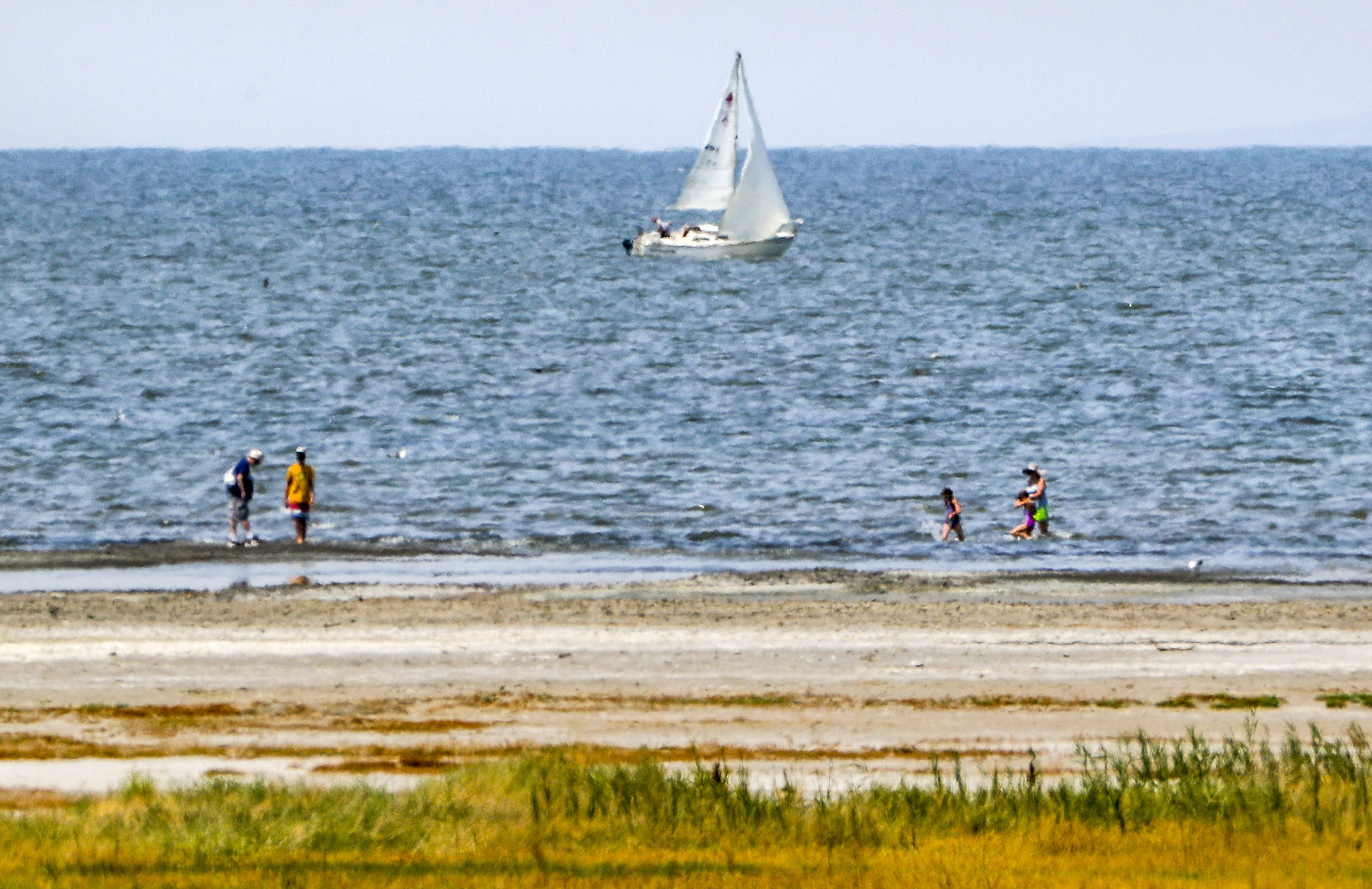 Heat waves obscure the view of a sailboat and beachgoers at the Great Salt Lake Marina on Aug. 5, 2020. A forecast released last week shows Utah has a greater probability of hotter and drier conditions this summer than most parts of the country.