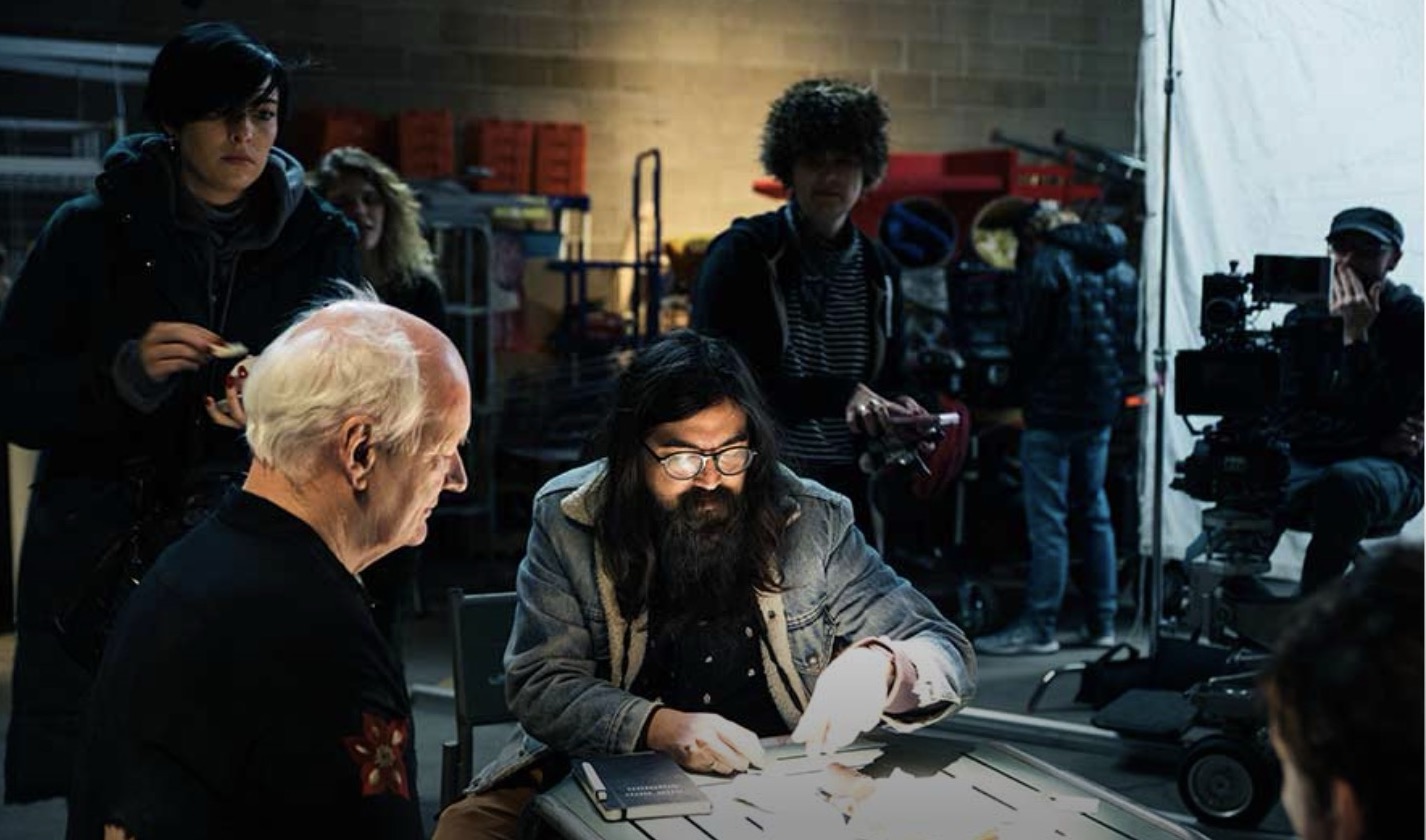 Jeremy Warner, center, works on the set of “Villains Incorporated” with actor Colin Mochrie, left, and other cast members.