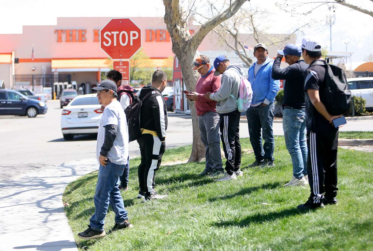Men wait for work opportunities near Home Depot in West Valley City on Tuesday.