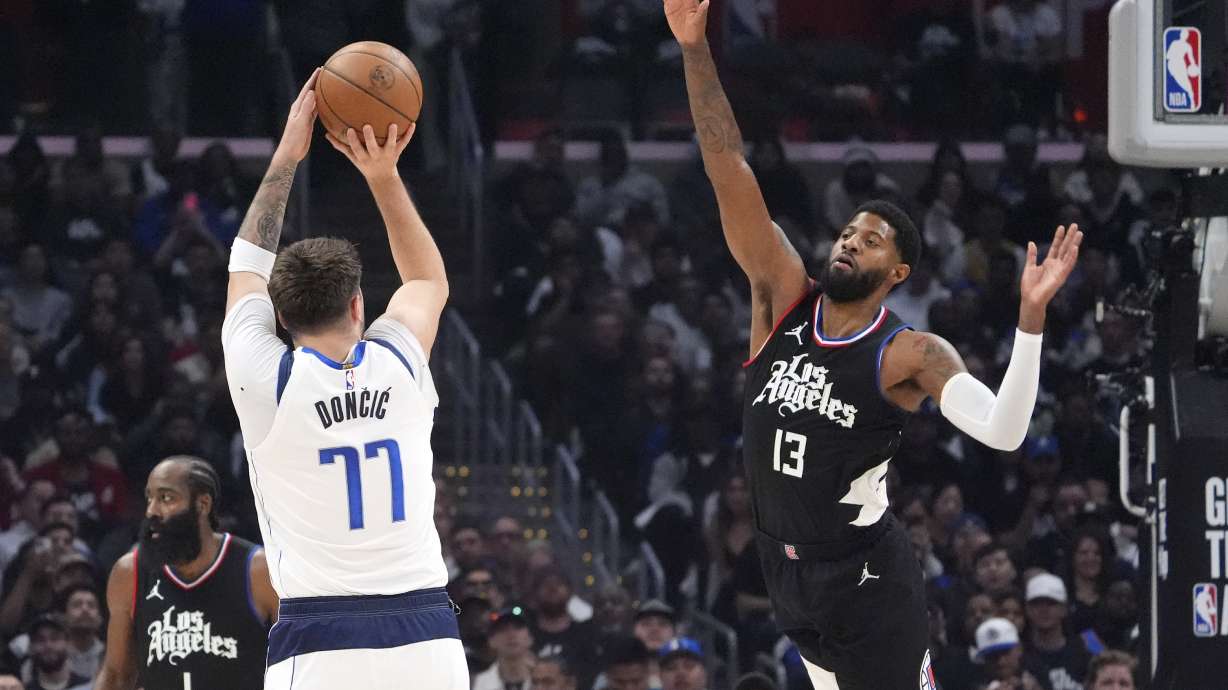 Dallas Mavericks guard Luka Doncic, center, shoots as Los Angeles Clippers forward Paul George, right, and guard James Harden defend during the first half in Game 2 of an NBA basketball first-round playoff series Tuesday, April 23, 2024, in Los Angeles.