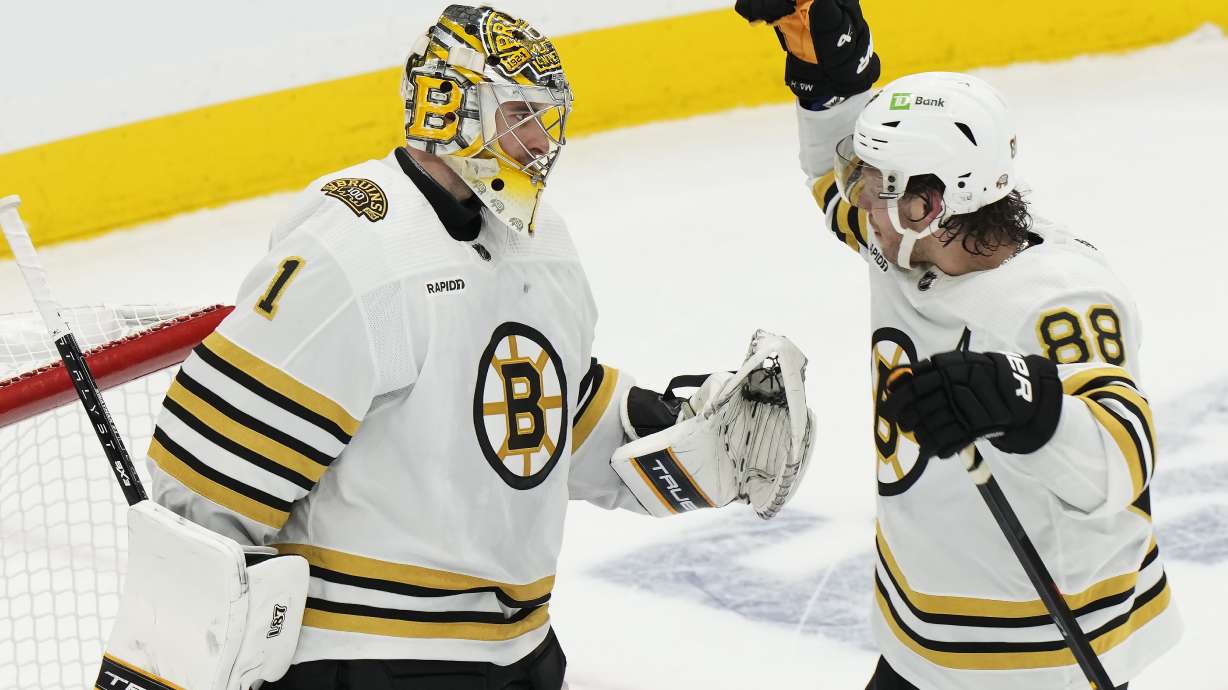 Boston Bruins goaltender Jeremy Swayman (1) and David Pastrnak (88) celebrate after defeating the Toronto Maple Leafs in Game 3 of an NHL hockey Stanley Cup first-round playoff series in Toronto on Wednesday, April 24, 2024.