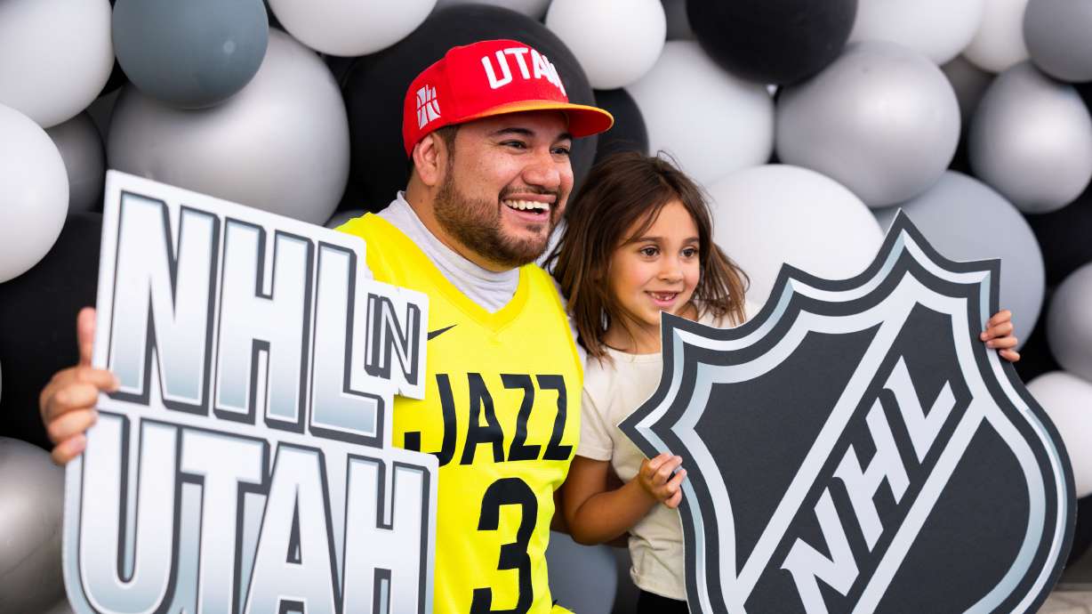 EJ and Ellie Ayala hold NHL signs in a photo booth at an event held to celebrate Utah’s new NHL team at the Delta Center in Salt Lake City on Wednesday.