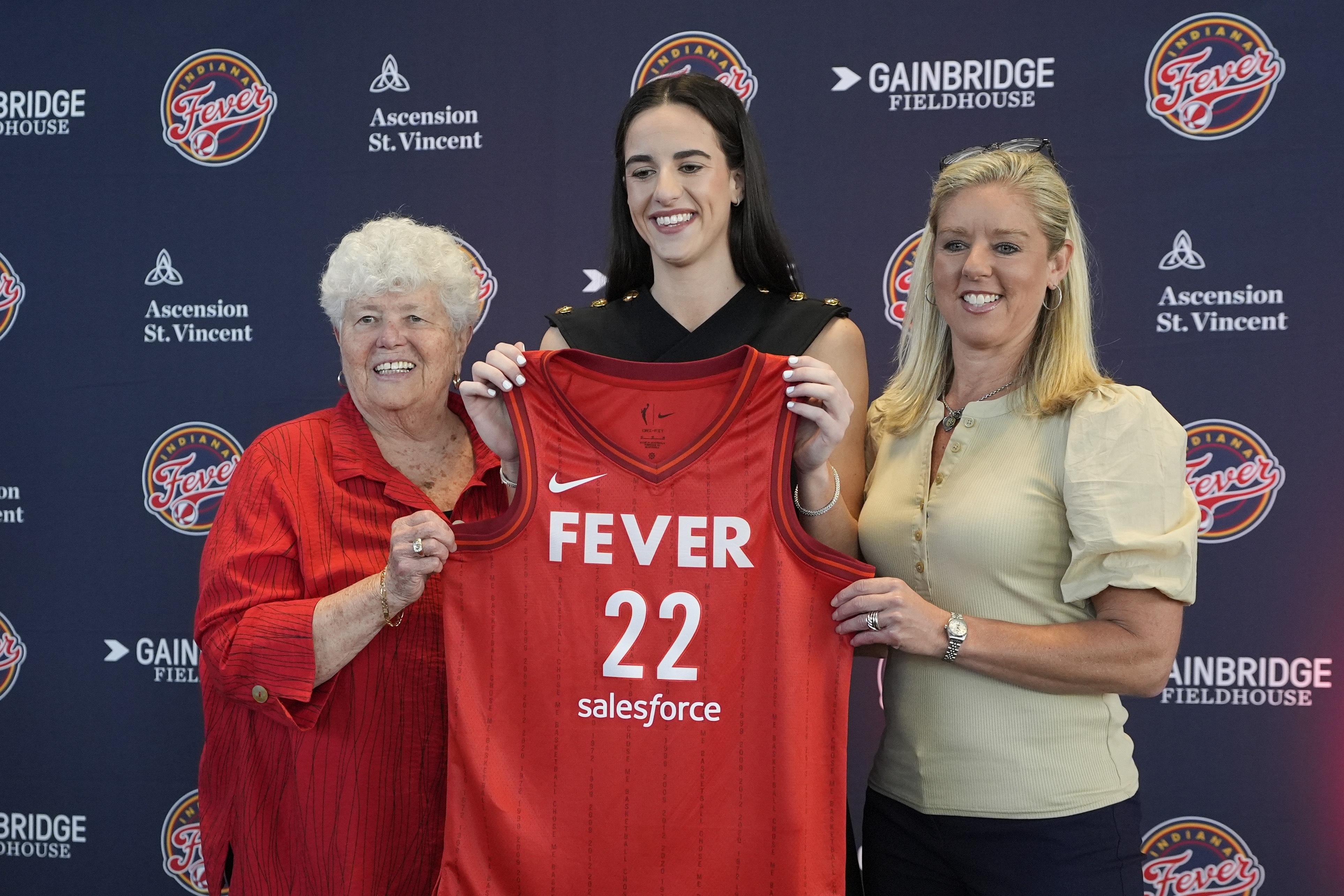 Indiana Fever's Caitlin Clark, middle, poses with general manager Lin Dunn, left, and head coach Christie Sides following a WNBA basketball news conference, Wednesday, April 17, 2024, in Indianapolis.