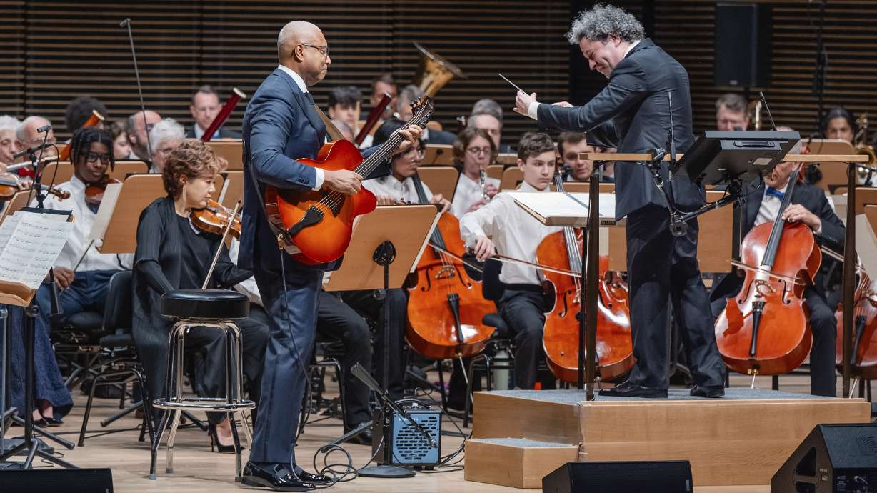 This image released by the New York Philharmonic shows former New York Yankees baseball player Bernie Williams, standing left, with conductor Gustavo Dudamel as he makes his New York Philharmonic debut in New York on Wednesday, April 24, 2024.