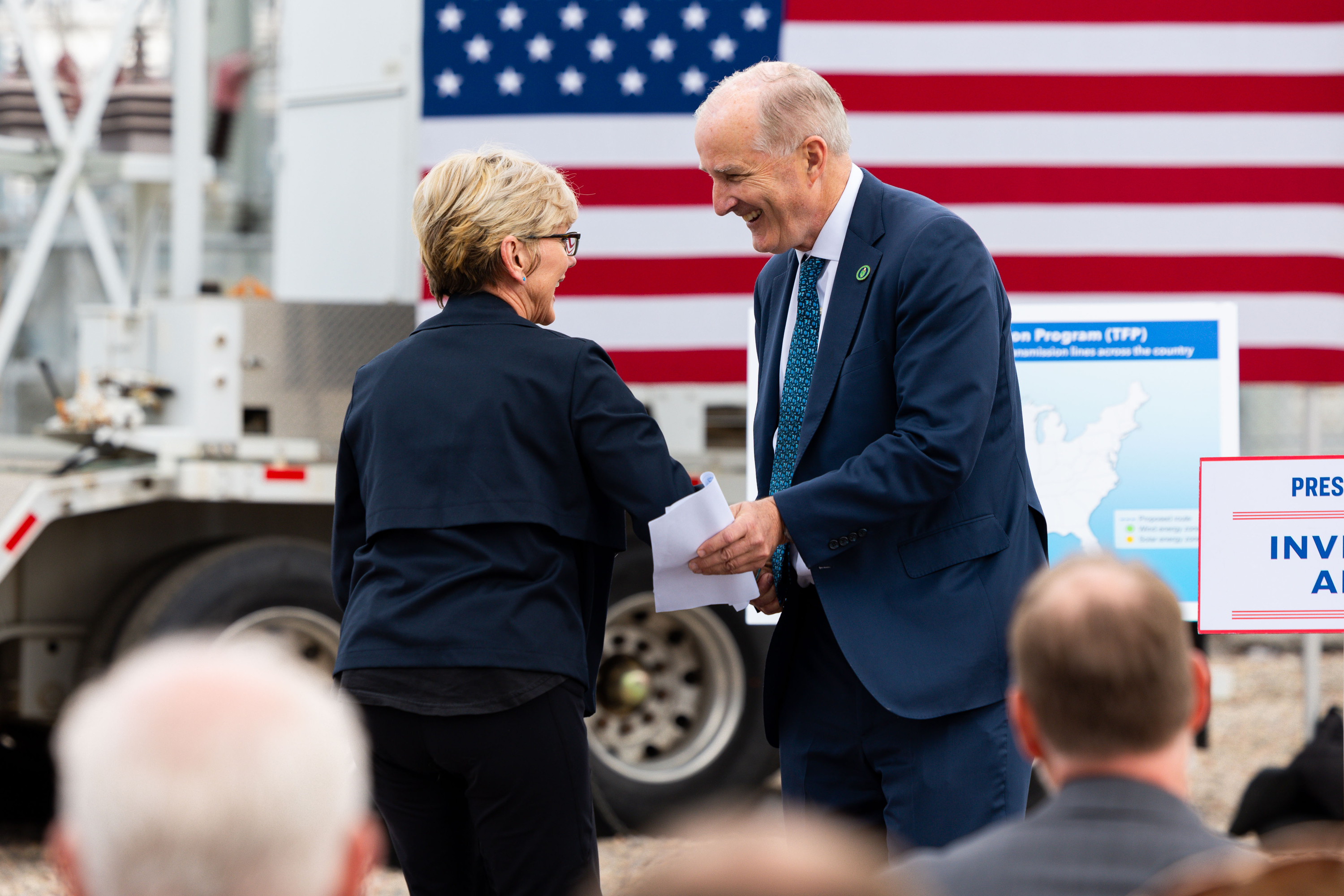 From right, Under Secretary for Infrastructure David Crane shakes hands with U.S. Department of Energy Secretary Jennifer M. Granholm at an electric substation in Salt Lake City on Thursday.