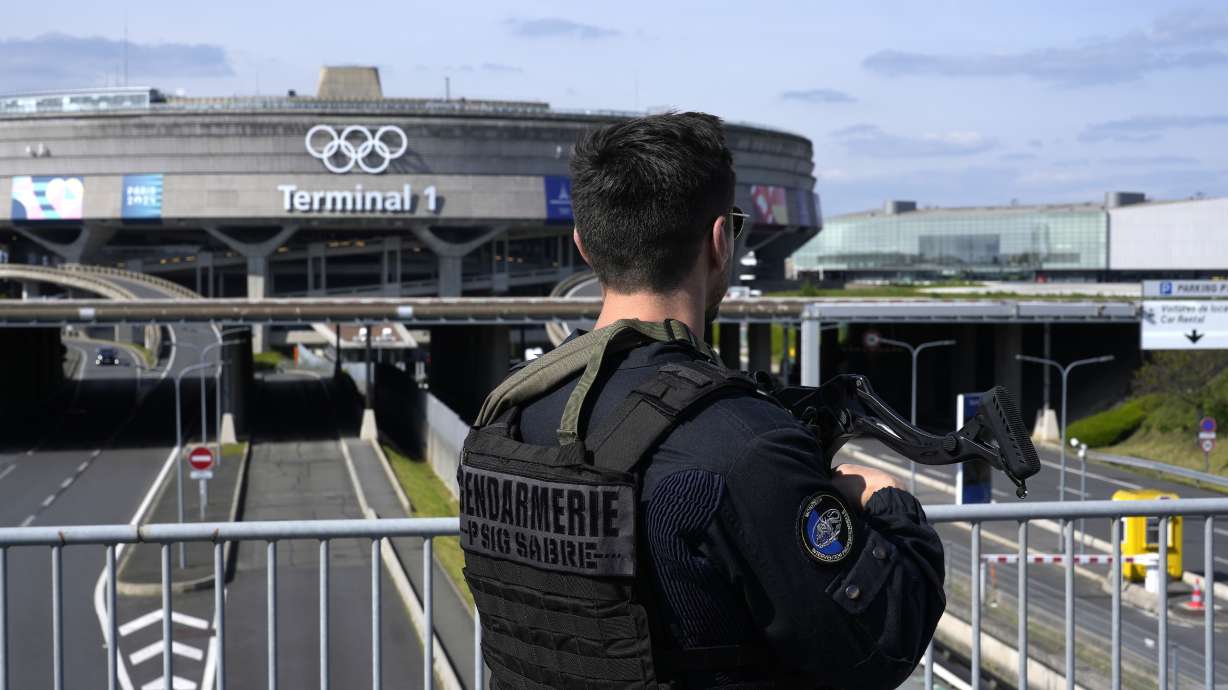 A gendarmes patrol in front of the Charles de Gaulle airport, terminal 1, where the olympic rings were installed, in Roissy-en-France, north of Paris, Tuesday, April 23, 2024 in Paris.