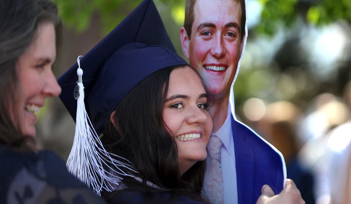 Kaitlyn Salazar hugs a cardboard statue of her brother, Jacob Schreiner, following the BYU commencement ceremony at the Marriott Center in Provo on Thursday.