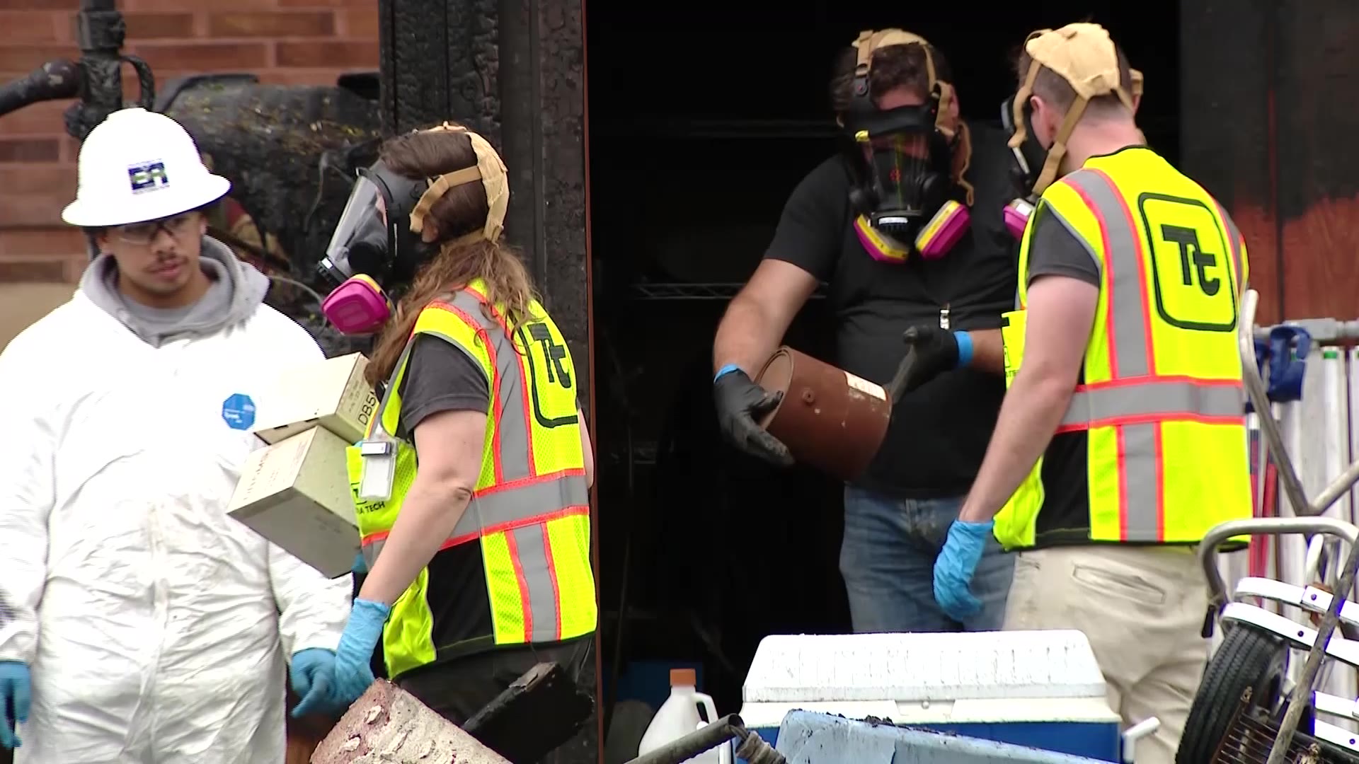 Members of the Environmental Protection Agency search through the remains of Teri Wojcik’s home on Thursday.