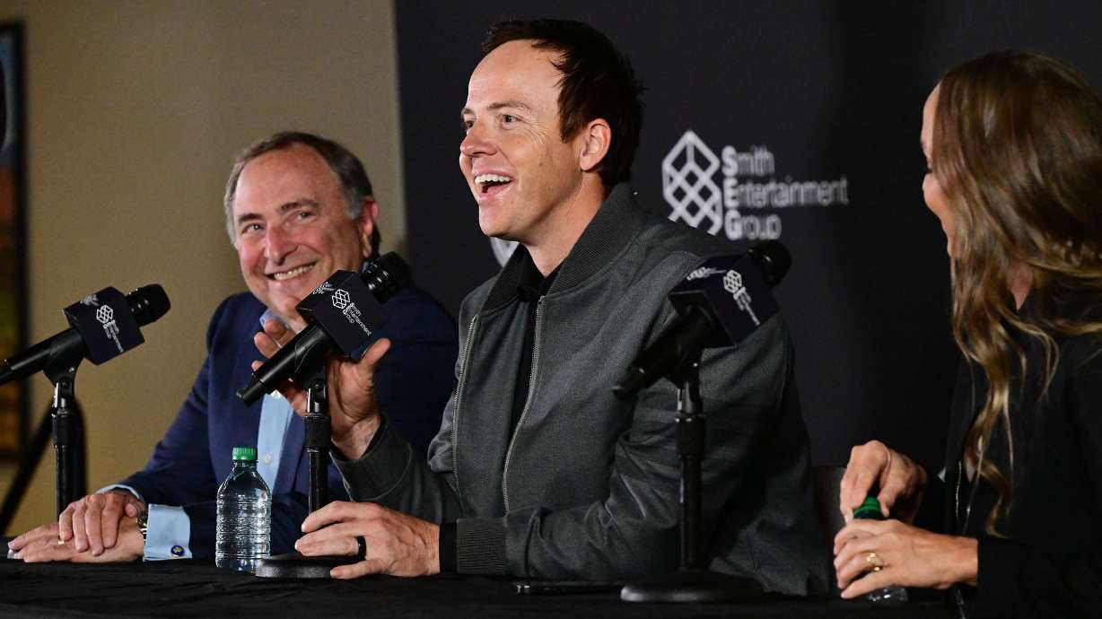 Ryan Smith, Ashley Smith and NHL Commissioner Gary Bettman speak in Salt Lake City April 18. Experts say Ryan Smith is on the path to become a power broker in the sports industry after buying multiple teams.