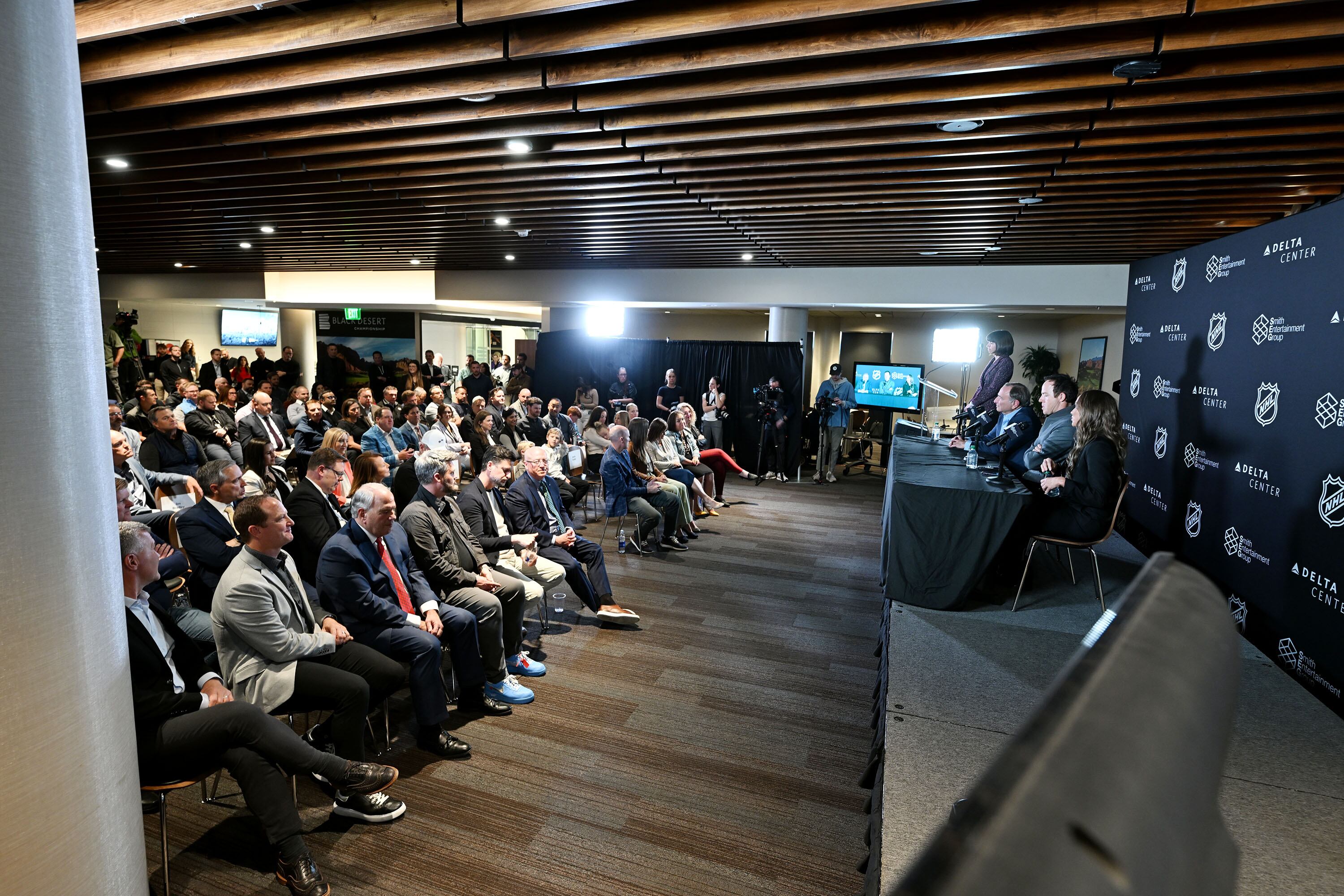 Ryan Smith, co-founder and chairman of Smith Entertainment Group, and Ashley Smith, co-founder of Smith Entertainment Group, and NHL Commissioner Gary Bettman join together at the Delta Center in Salt Lake City to announce that the NHL would be coming to Utah on April 18.