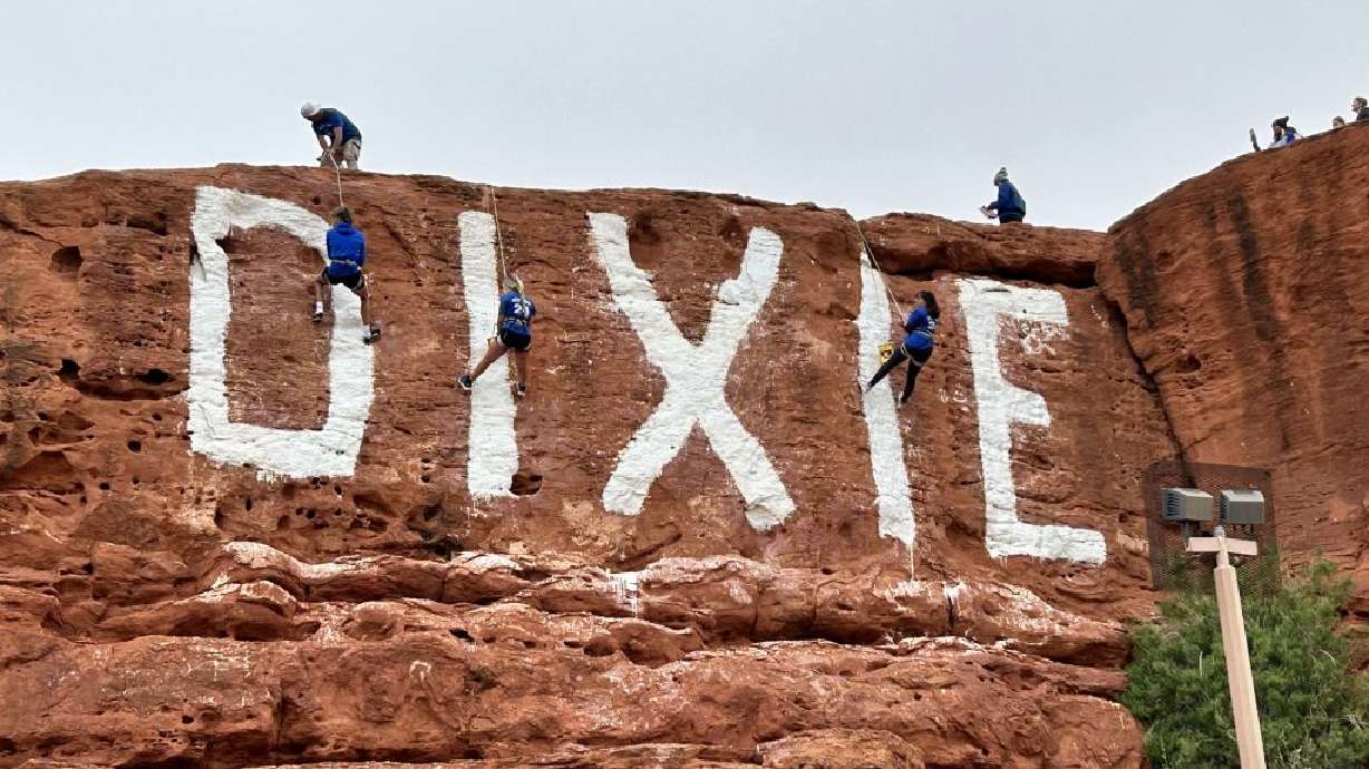 Students rappel down the Sugarloaf repainting "Dixie" as part of the annual Bucket Run in St. George on Friday.
