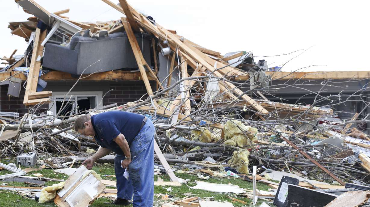 Terry Kicking sifts through the damage after a tornado leveled his home, Friday, in Omaha, Neb.