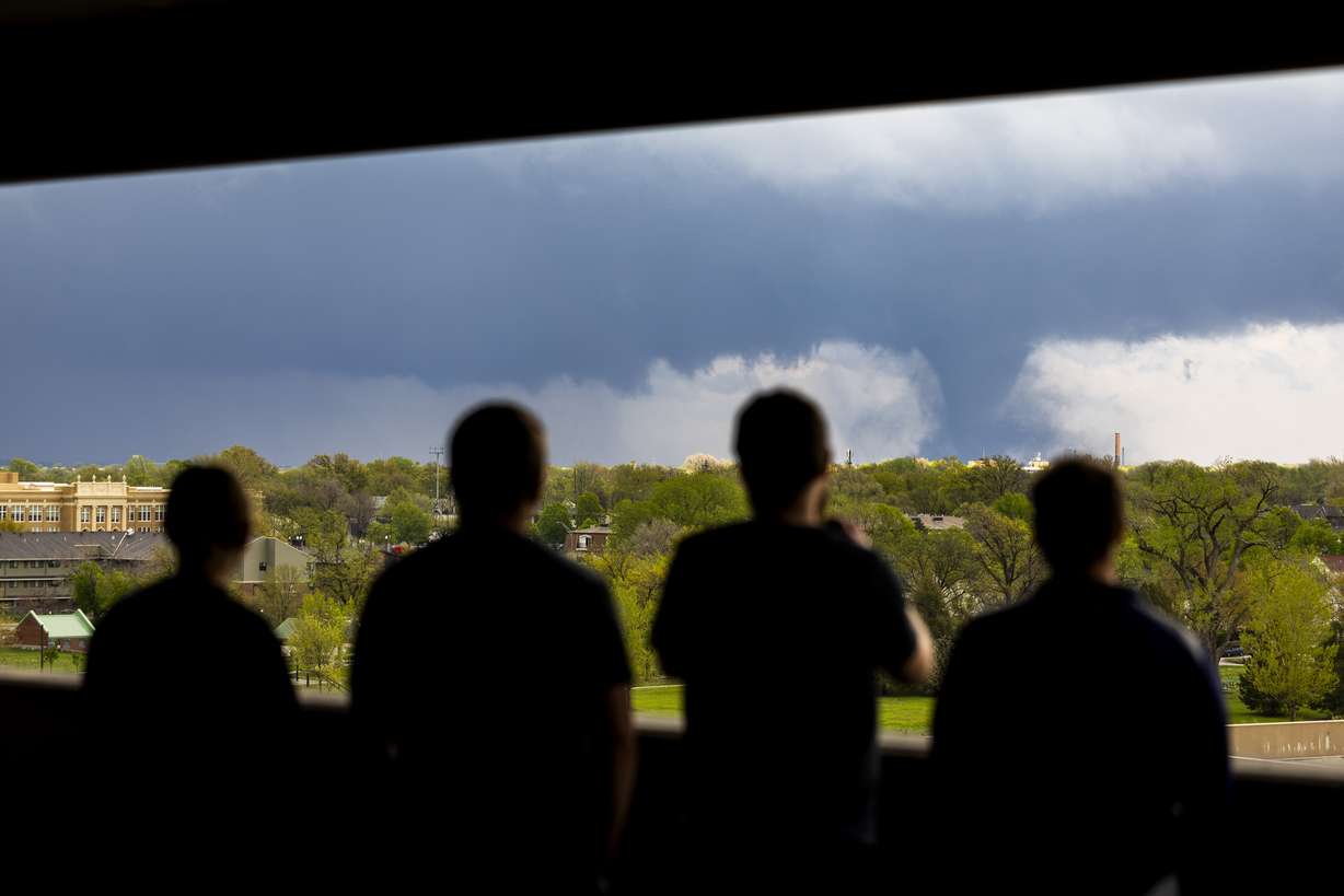 From left, Ally Mercer, Gabe Sedlacek Kaleb Andersen and Austin Young watch a tornado from a seventh-floor parking garage on Friday, in Lincoln, Neb.