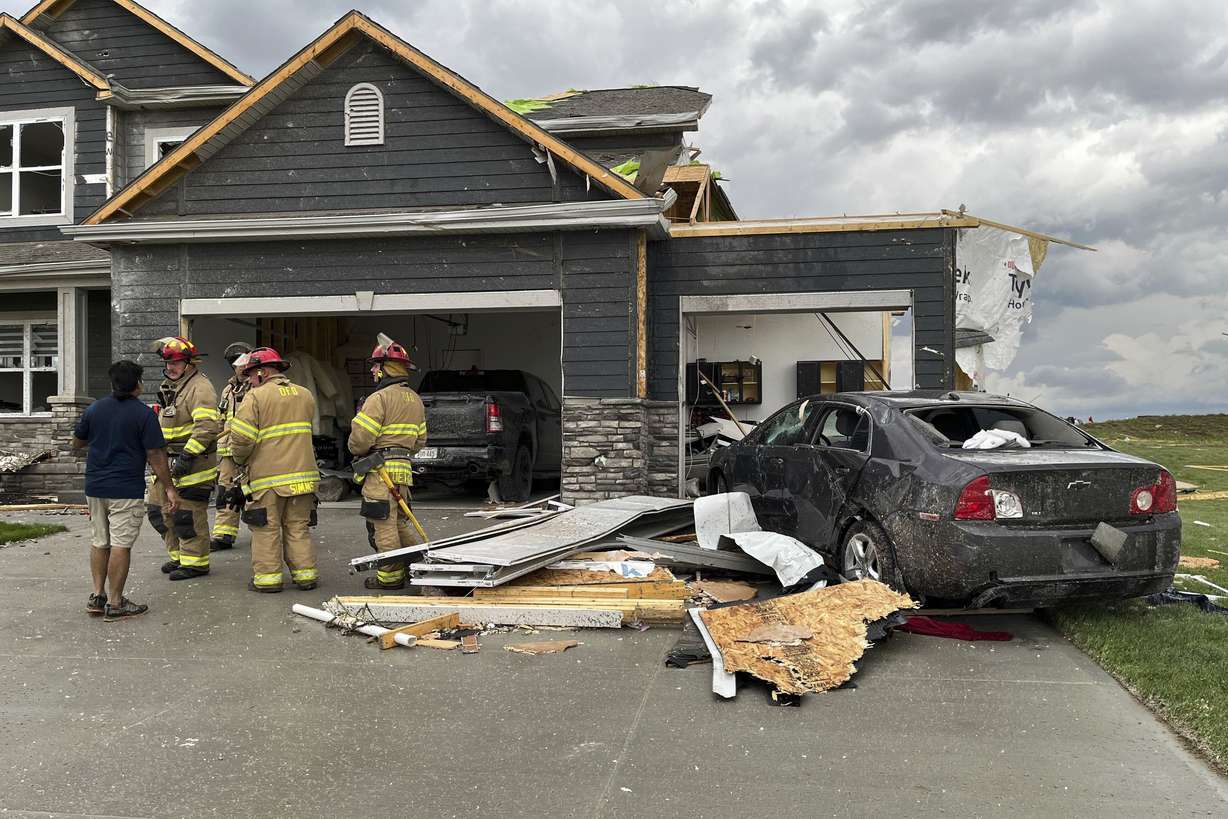 Firefighters work to clear a home damaged by a tornado northwest of Omaha, Neb., on Friday.