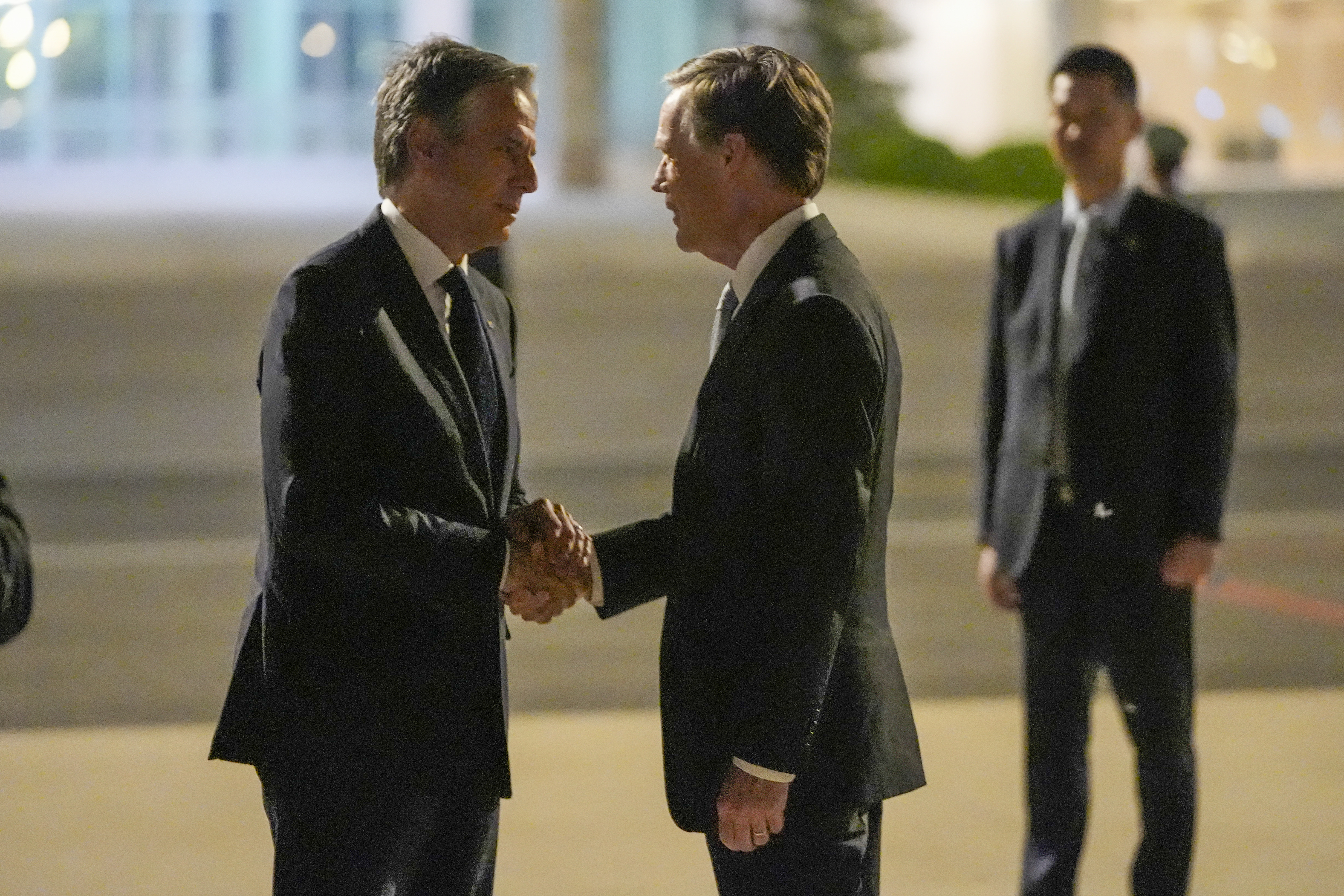 U.S. Secretary of State Antony Blinken shakes hands with U.S. ambassador to China Nicholas Burns as he prepares to return to the U.S. following a visit to China, Friday, at Beijing Capital International Airport.