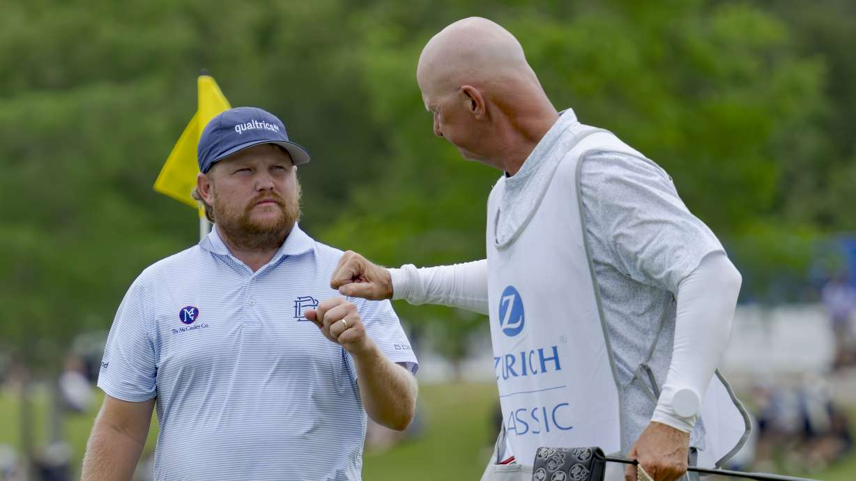 Zac Blair, left, fist-bumps the caddie of Patrick Fishburn after their team finished the third round of the PGA Zurich Classic golf tournament at TPC Louisiana in Avondale, La., Saturday, April 27, 2024.