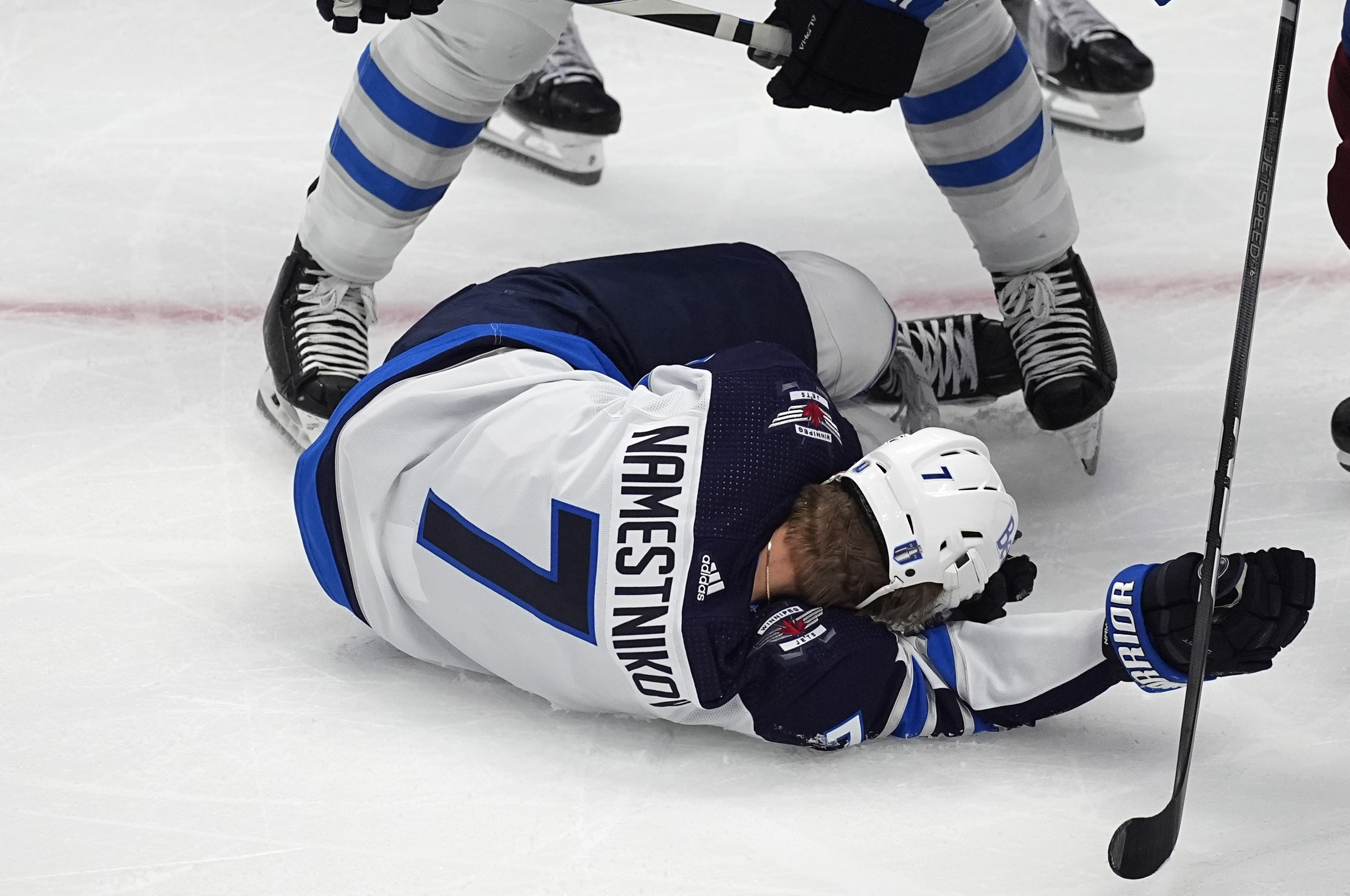 Winnipeg Jets center Vladislav Namestnikov (7) falls to the ice after taking a slap shot to the face in the third period of Game 4 of an NHL Stanley Cup first-round playoff series against the Colorado Avalanche, Sunday, April 28, 2024, in Denver.