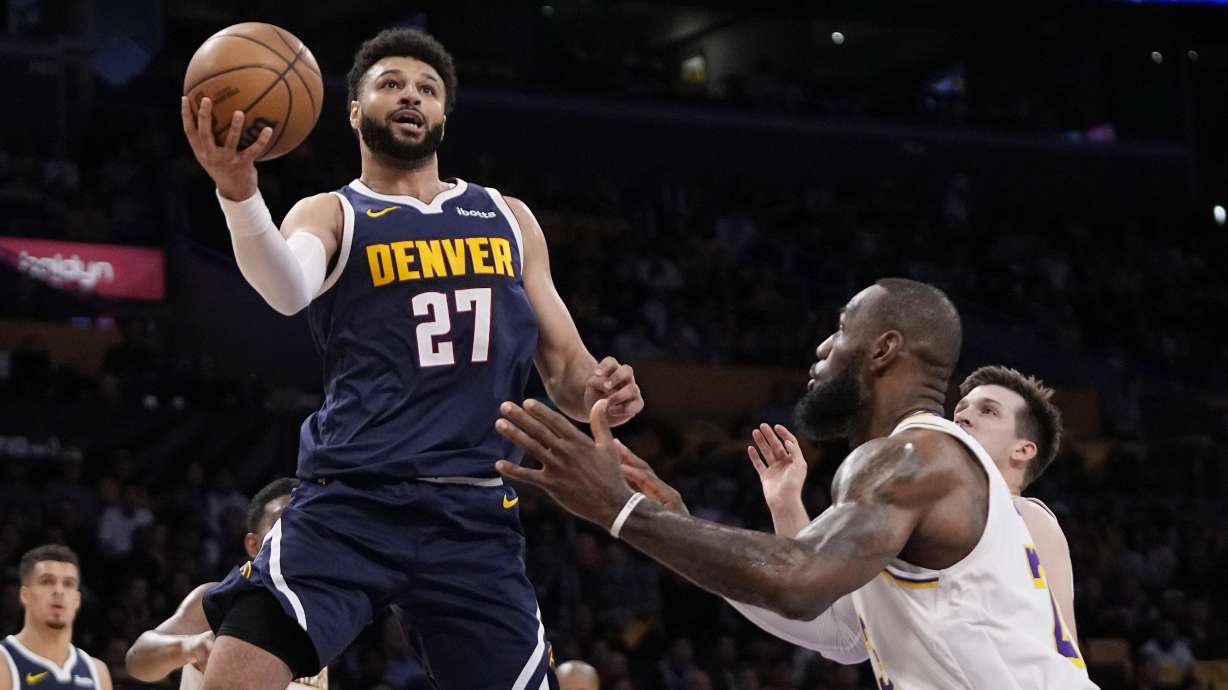 Denver Nuggets guard Jamal Murray, left, shoots as Los Angeles Lakers forward LeBron James defends during the first half in Game 4 of an NBA basketball first-round playoff series Saturday, April 27, 2024, in Los Angeles.