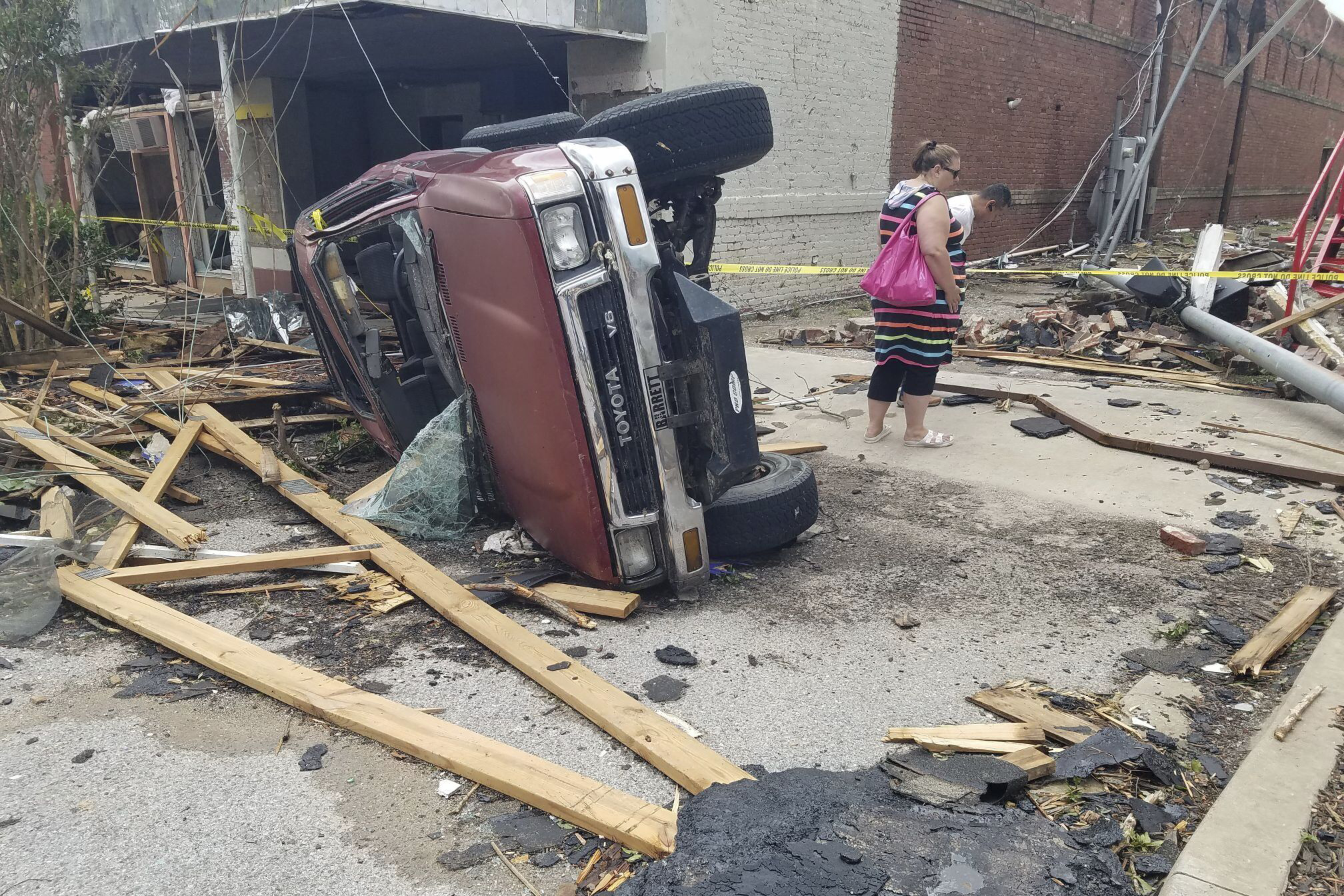 A car lies on its side after being knocked over during a tornado that tore through downtown Sulphur, Okla., Sunday.