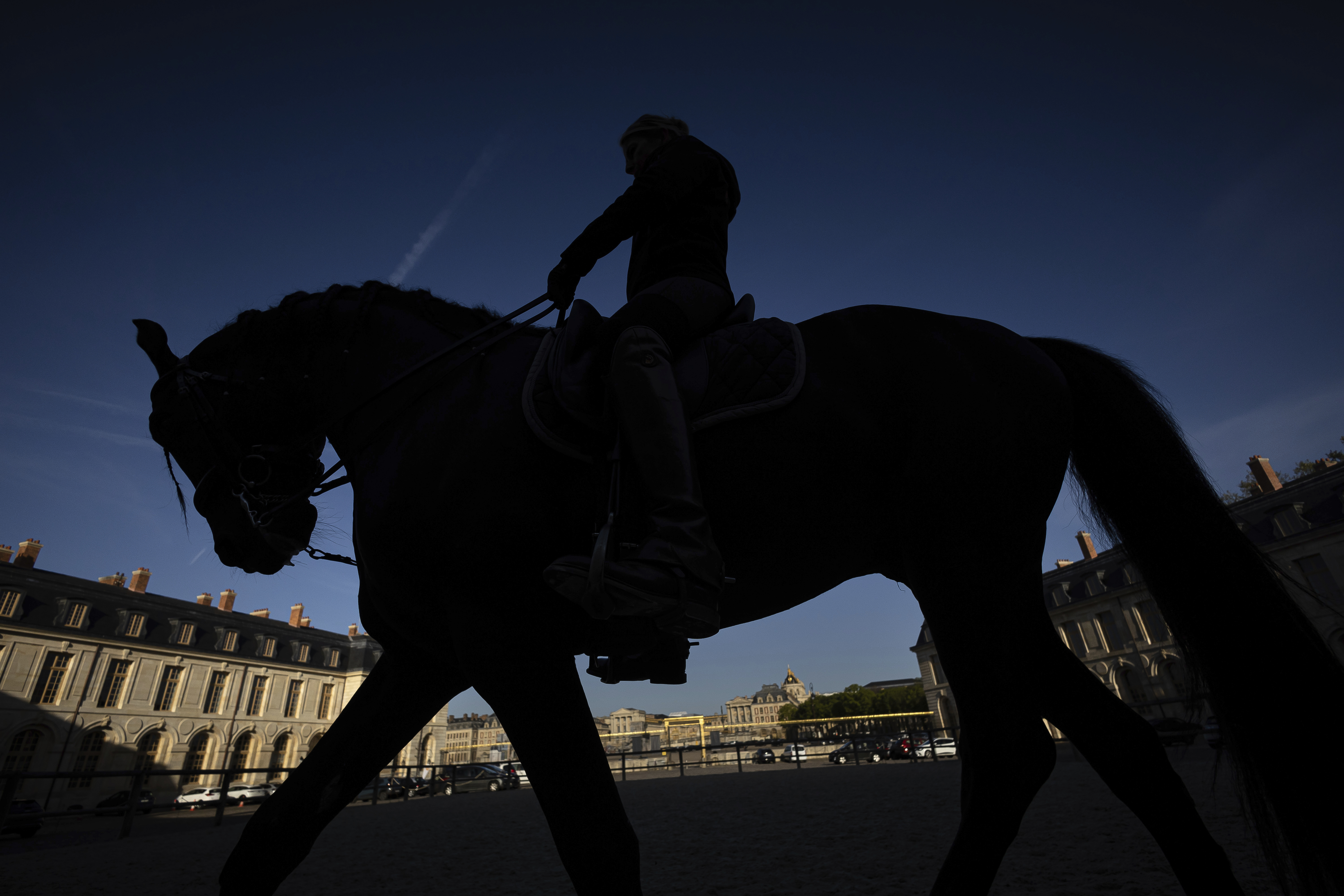 A horsewoman trains with her horse in the main courtyard of the royal stables, in Versailles, Thursday, April 25, 2024. More than 340 years after the royal stables were built under the reign of France's Sun King, riders and horses continue to train and perform in front of the Versailles Palace. The site will soon keep on with the tradition by hosting the equestrian sports during the Paris Olympics. Commissioned by King Louis XIV, the stables have been built from 1679 to 1682 opposite to the palace's main entrance.