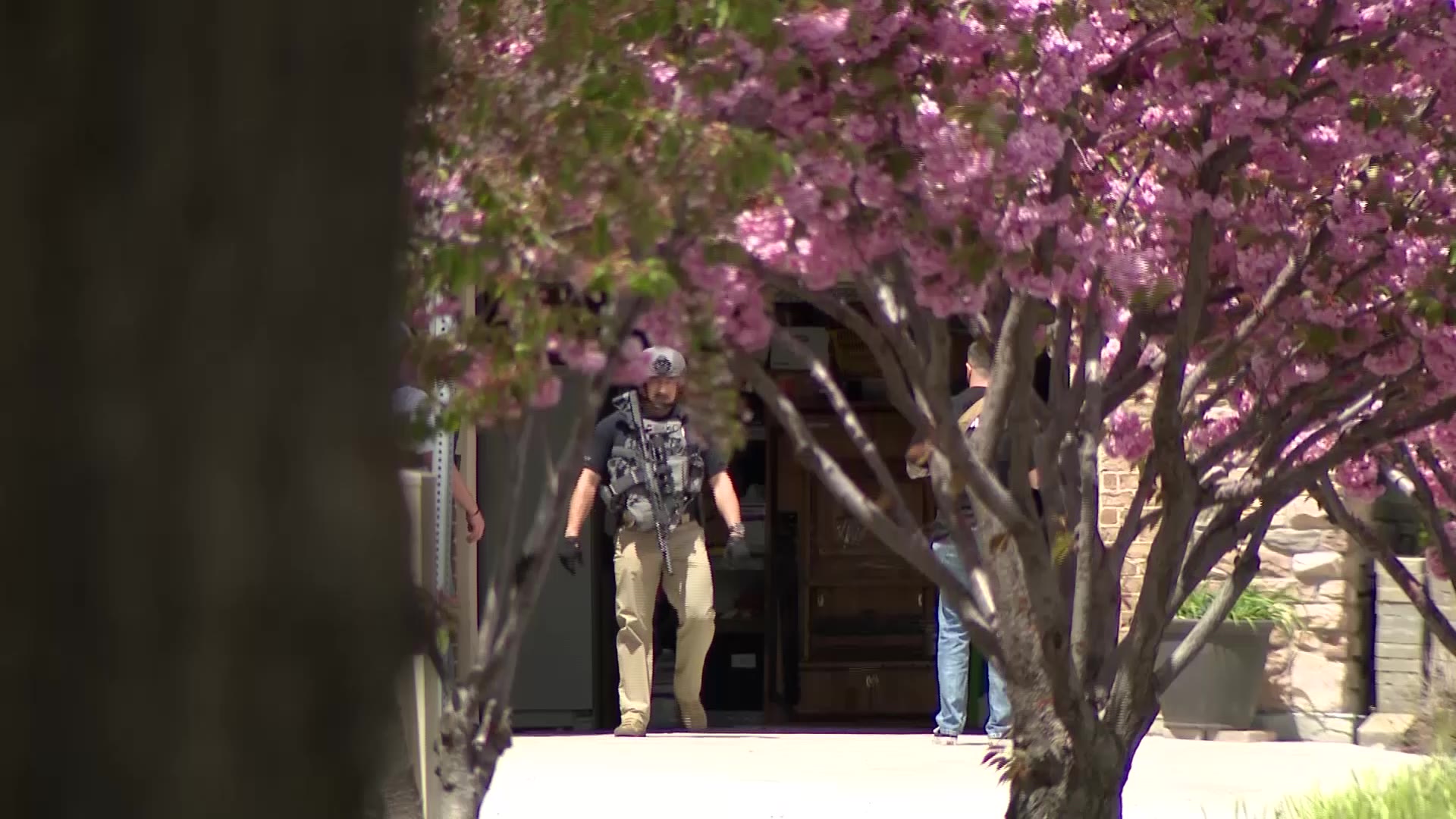 Armed first responders exit the West Jordan home where a fake a fake 911 call led to a significant emergency response in West Jordan on Monday.