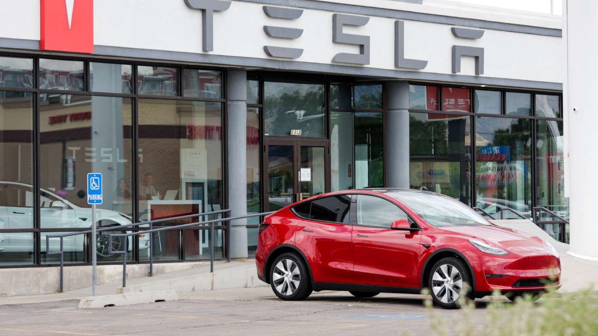 A Tesla sits outside a Tesla dealership in Salt Lake City on July 12, 2022. EV maker is facing multiple lawsuits in the year ahead amid a slowing market growth and layoffs.