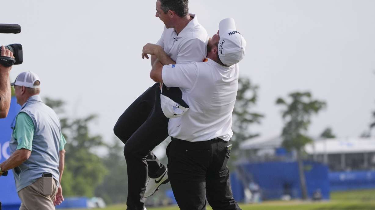 Shane Lowry, of Ireland, hoists up teammate Rory McIlroy, of Northern Ireland, after they won the PGA Zurich Classic golf tournament at TPC Louisiana in Avondale, La., Sunday, April 28, 2024.
