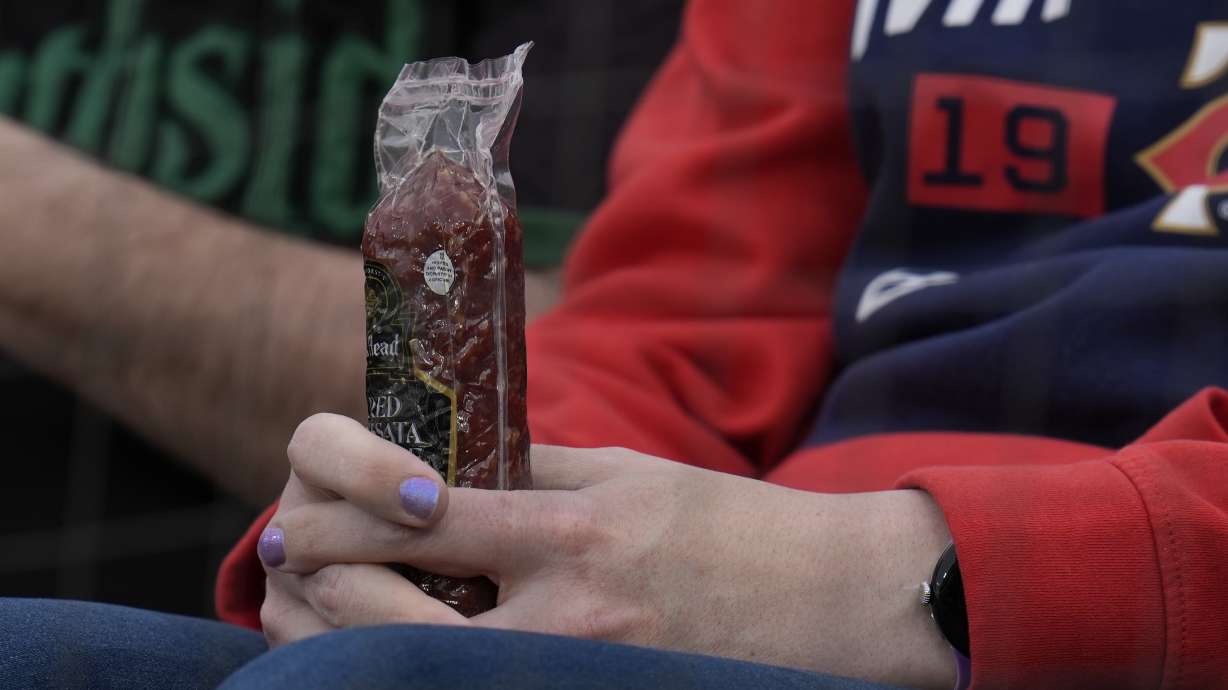 A Minnesota Twins fan holds a sausage before a baseball game against the Chicago White Sox, Monday, April 29, 2024, in Chicago. The Twins recently began passing around summer sausages in the dugout.