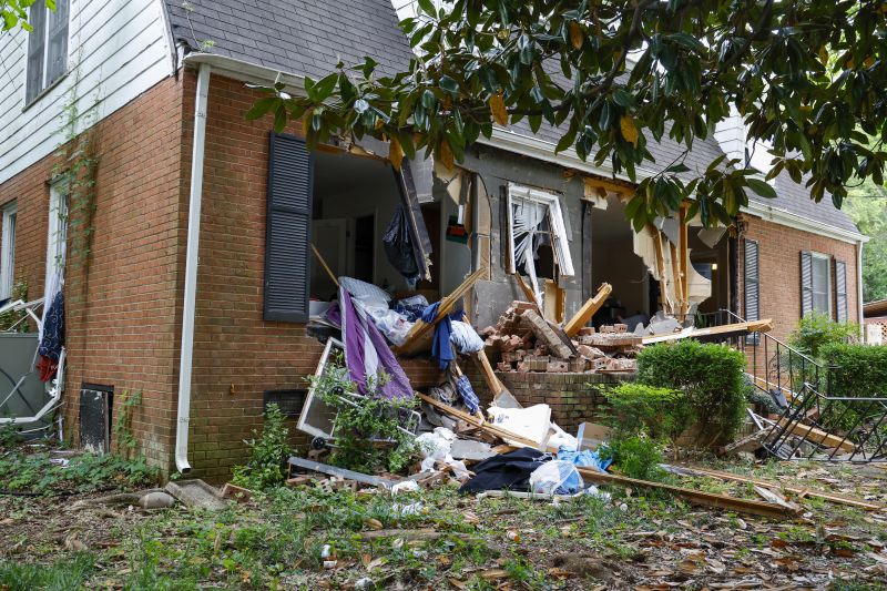 Debris surrounds a home, Tuesday, where a shootout between a suspect and officers occurred on Monday, in Charlotte, N.C.  Police say a shootout that killed four law enforcement officers and wounded four others began as officers approached the home to serve a warrant for a felon wanted for possessing a firearm.