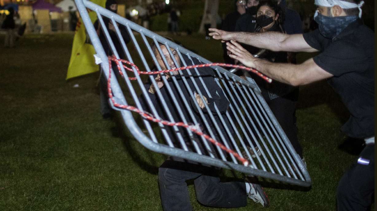 Demonstrators clash at a pro-Palestinian encampment at UCLA early Wednesday, in Los Angeles. Dueling groups of protesters have clashed at the University of California, Los Angeles, grappling in fistfights and shoving, kicking and using sticks to beat one another.