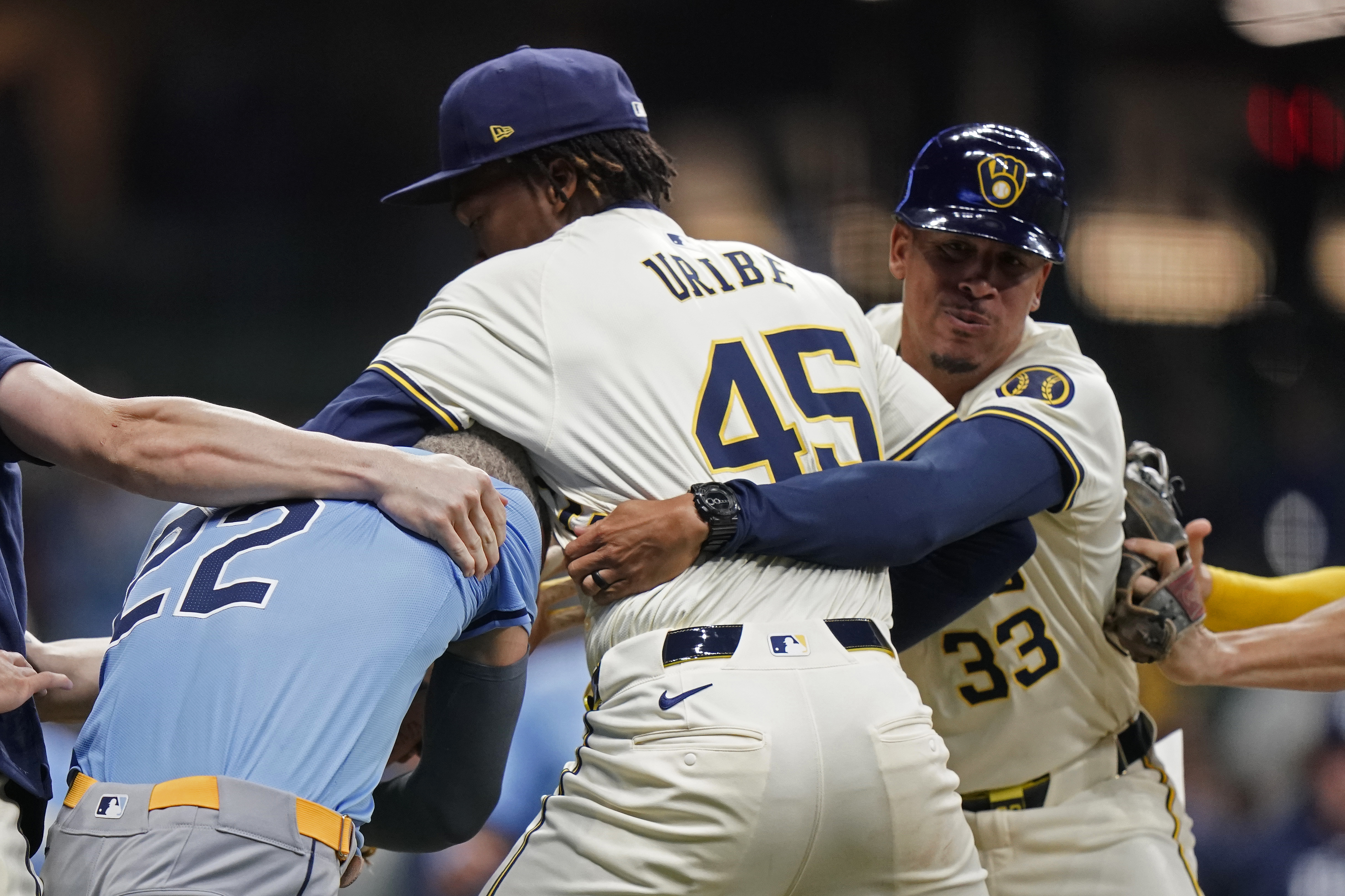 Milwaukee Brewers' Abner Uribe (45) is held back by Quintin Berry (33) as he fights with Tampa Bay Rays' Jose Siri (22) during the eighth inning of a baseball game Tuesday, April 30, 2024, in Milwaukee. 